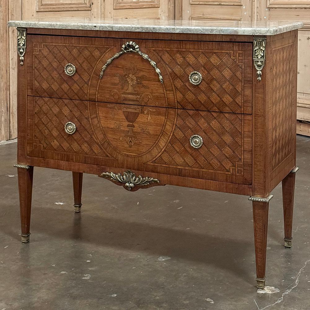 Louis XVI Marquetry Marble Top Commode with Bronze Mounts is a timeless rendition of the neoclassic style!  Rendered from indigenous hardwoods, it features an intricate parquet background on the sides and front, centered with an oval artistically