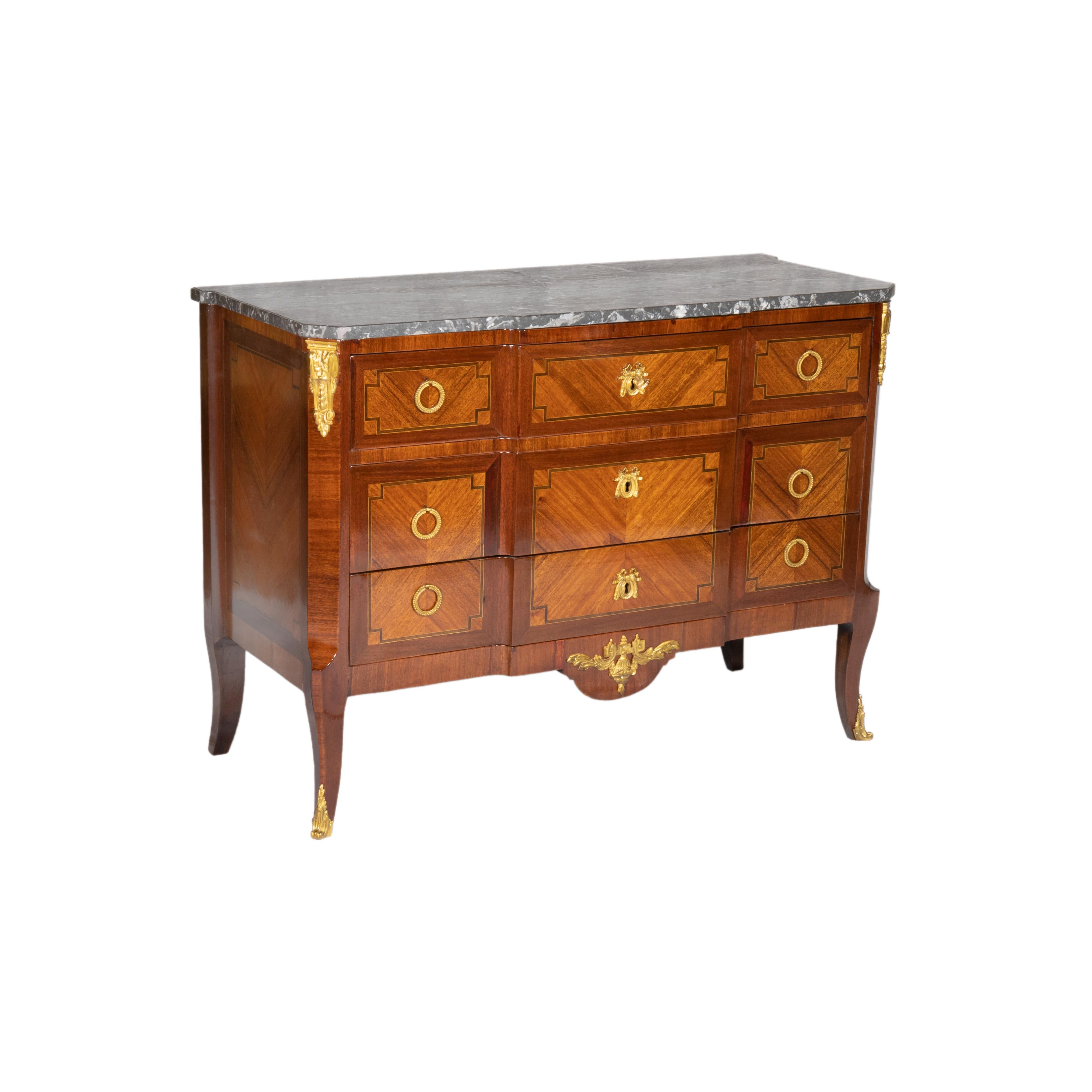 A marble top of breakfront shape french Empire commode with tapered feet adorned, chiseled brass shoes, handles and friezes intricately bronze chiseled. The side flanks showcase fourleaf framed exotic parquetry inlaid borders, while the top boasts