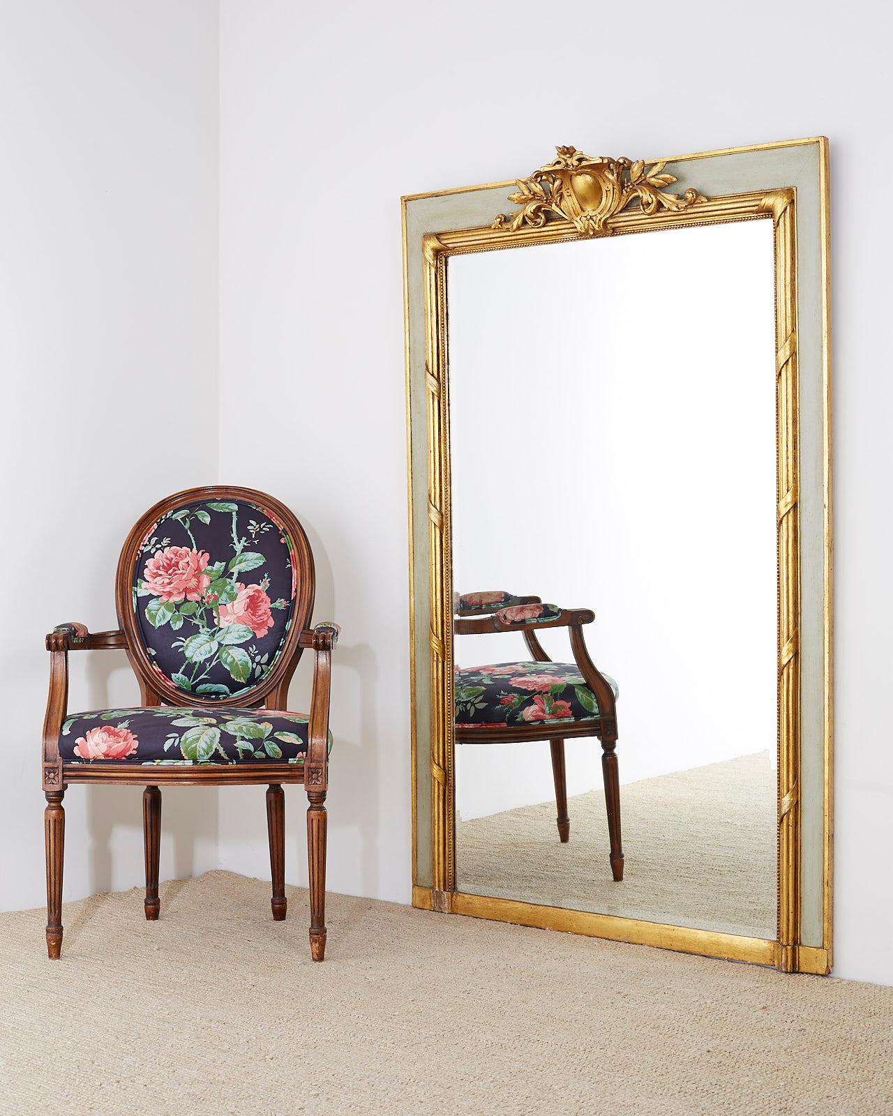 Fantastic French 19th century giltwood trumeau, pier glass, console, or wall mirror. Made in the Louis XVI neoclassical taste featuring a carved armorial decorative top over the large beveled plate glass. The mirror has a wide frame with the inner