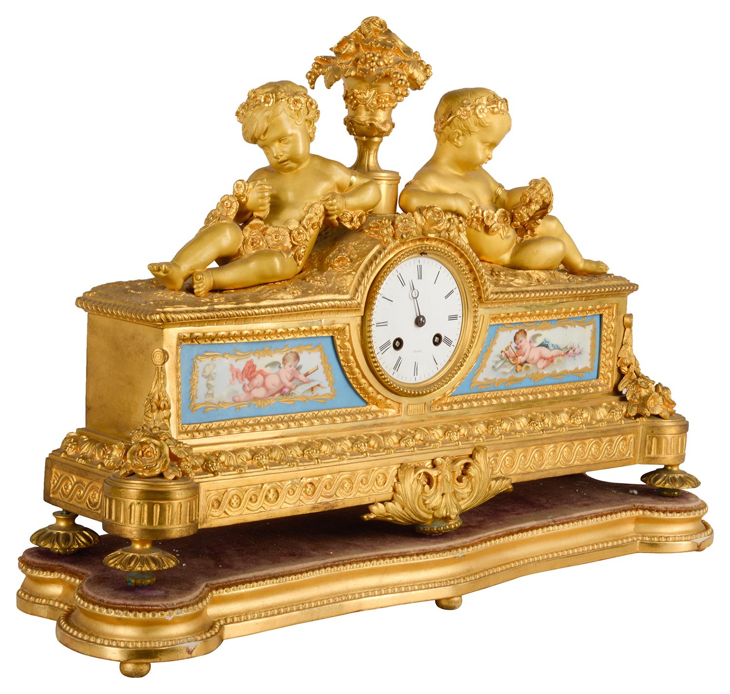 A good quality 19th century gilded ormolu Louis XVI style mantle clock, having reclining putti holding garlands of flowers either side a vase of flowers, two serves style porcelain panels depicting cherubs representing art and music. The white