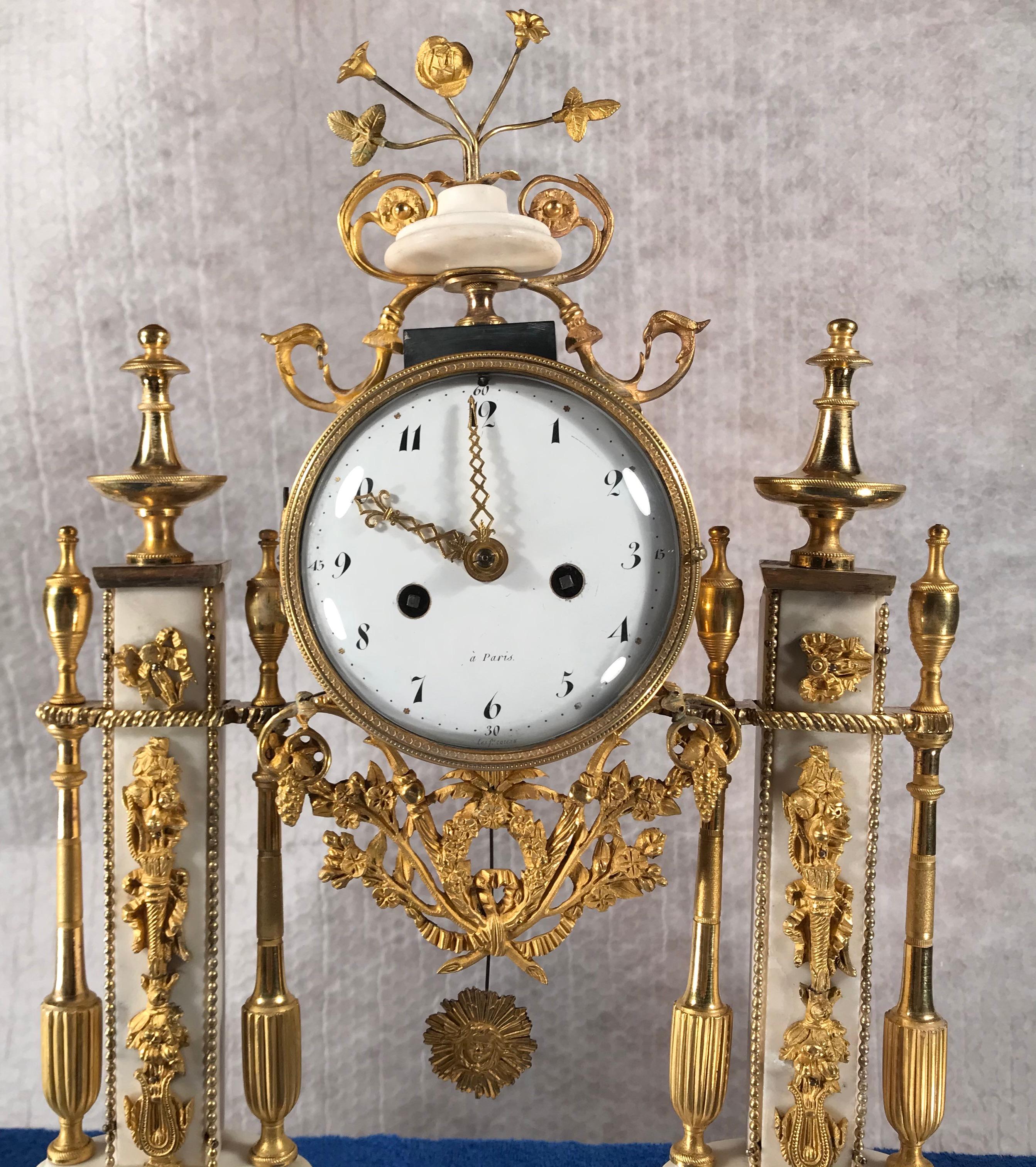 Louis XVI ormolu-mounted black and white marble mantel clock, Paris, 1800.
The white enamel dial with black Arabic numerals is contained within a drum-shaped case. The case flanked by gilt bronze mounted pilaster set on top of a black marble
