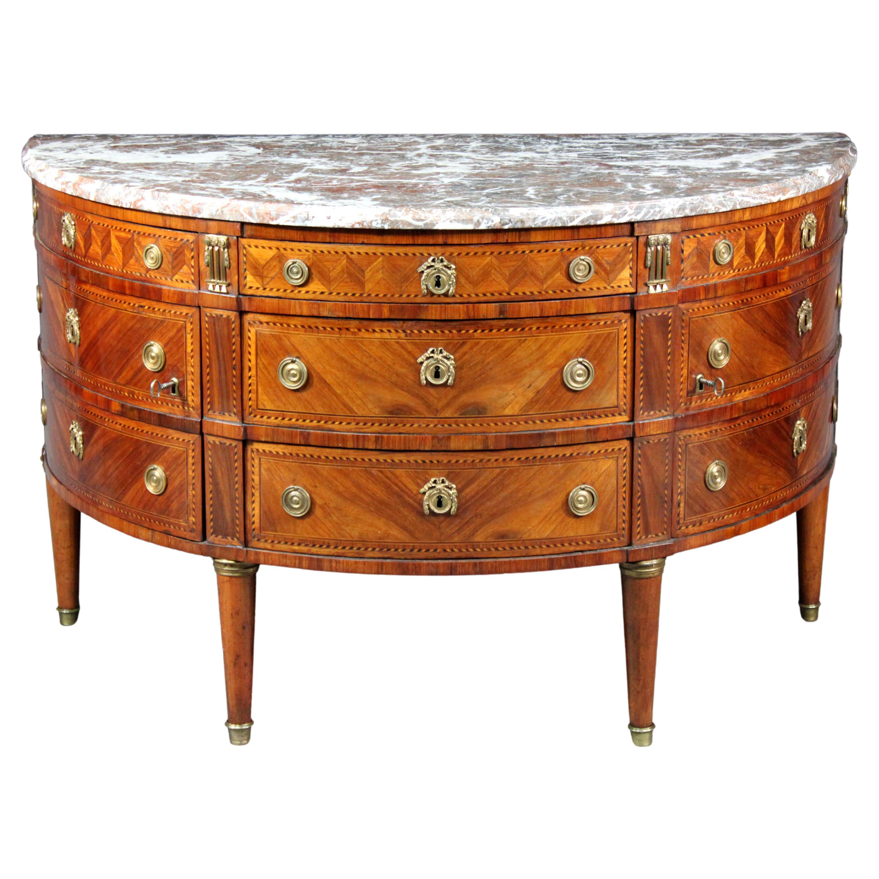 Commode Louis XVI en bois de roi démilunie et montée sur bronze doré