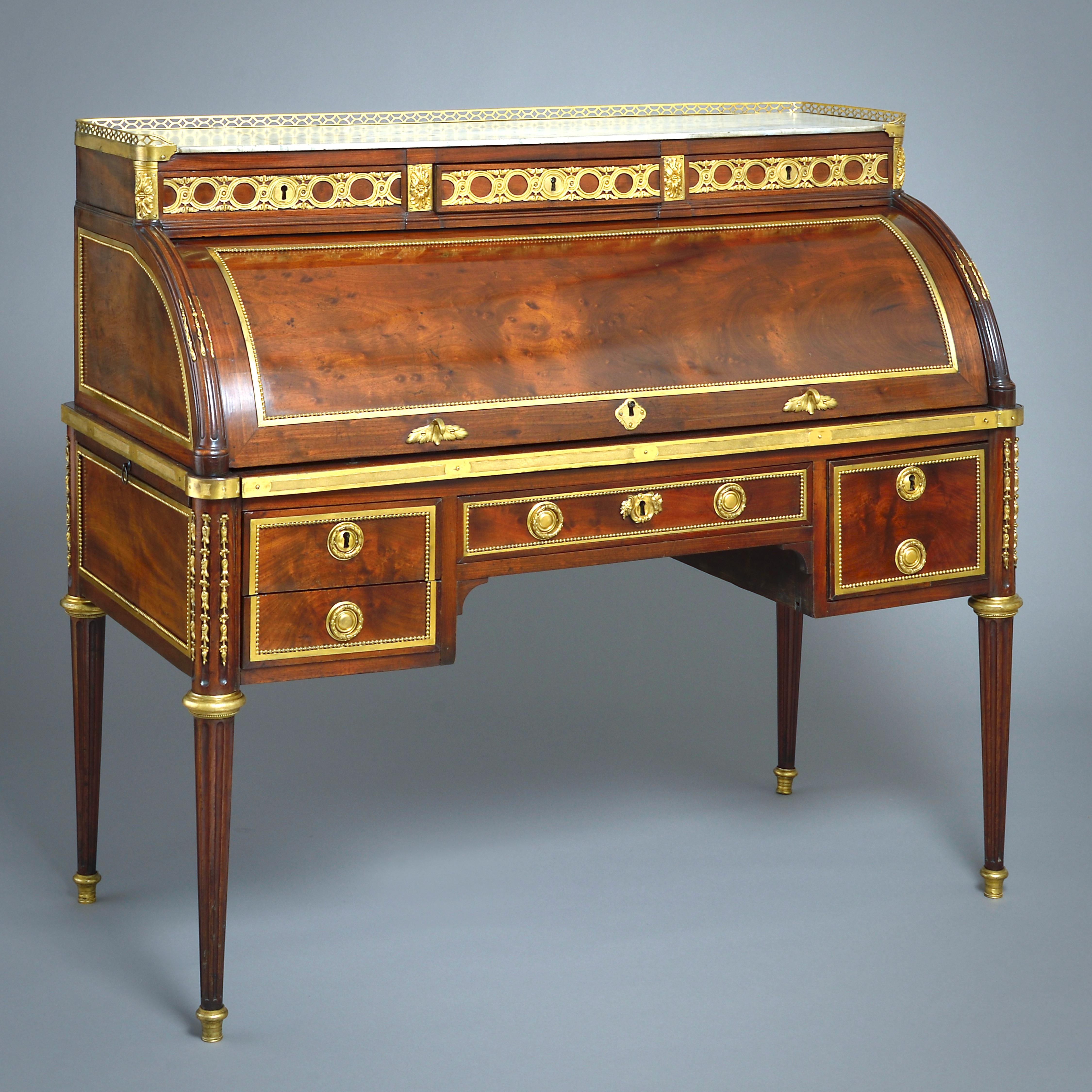RAFFINATO BUREAU À CYLINDRE IN MOGANO CON MONTATURA IN ORMOLU DI LOUIS MOREAU, 1790 CIRCA.

Con tre cassetti a fregio sotto il piano in marmo venato, il cilindro che racchiude una superficie di scrittura estraibile con la sua pelle originale in