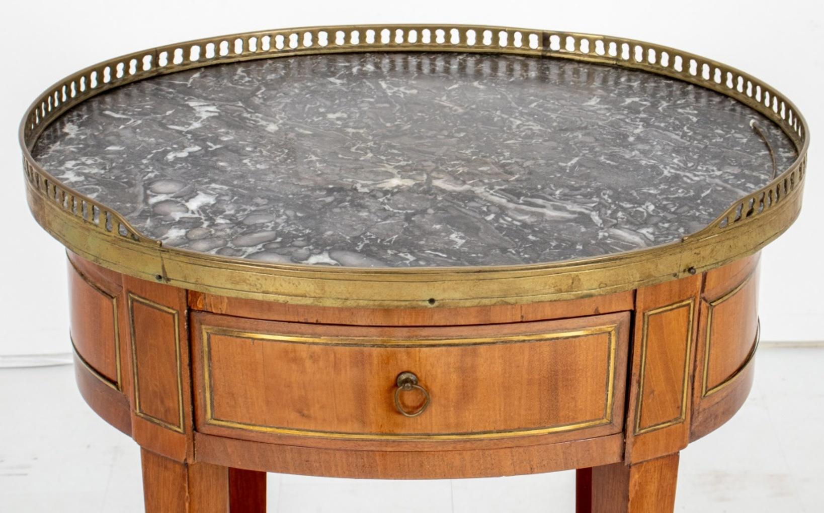 Louis XVI oval brass-mounted mahogany table, 18th C and later, apparently unmarked, the galleried oval fossilized marble top above paneled apron with one short drawer above four tapering square legs conjoined by a conforming tier. 

Dealer: S138XX