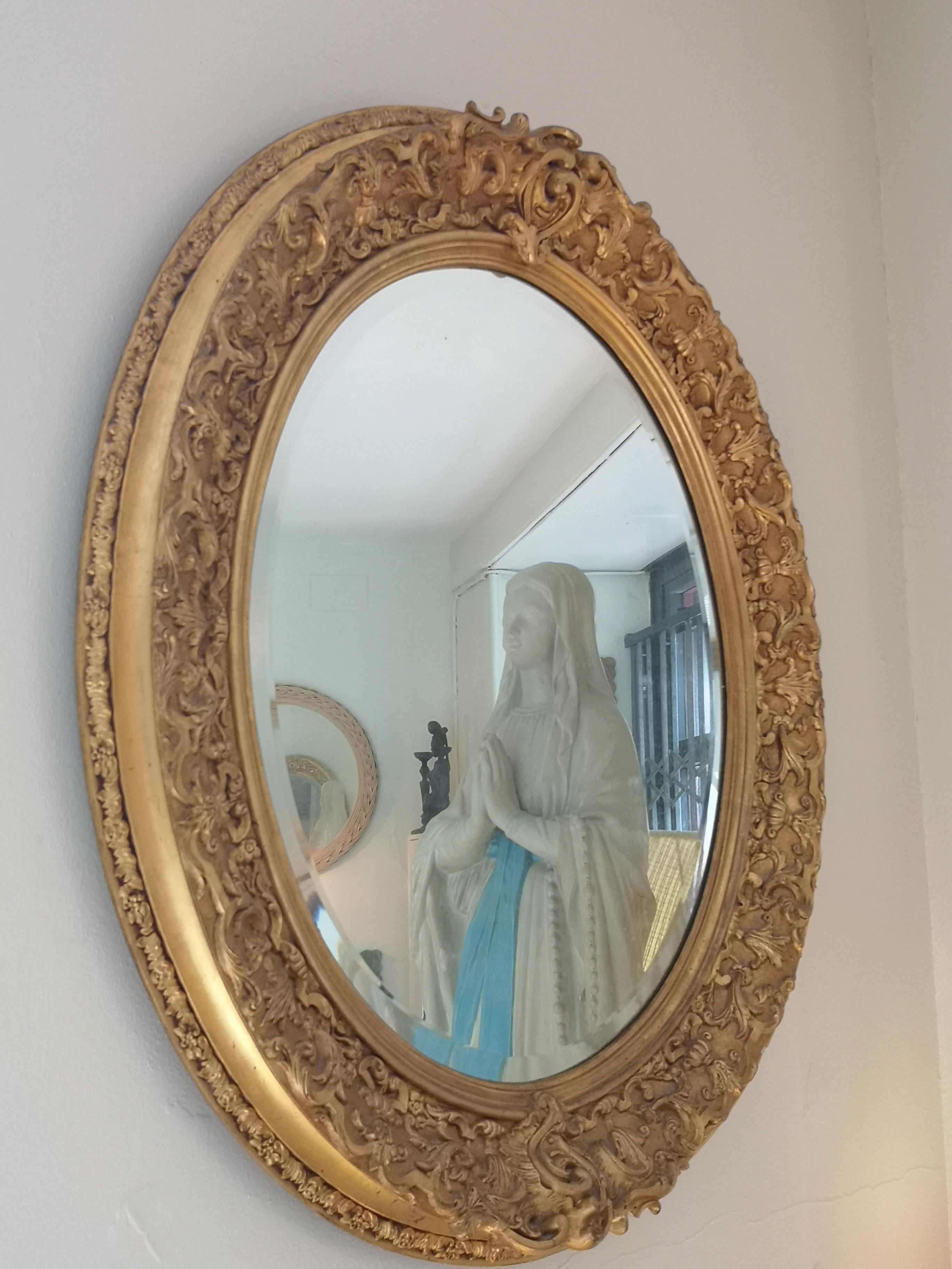 German Louis XVI oval mirror in gilded wood and stucco from the 19th century For Sale