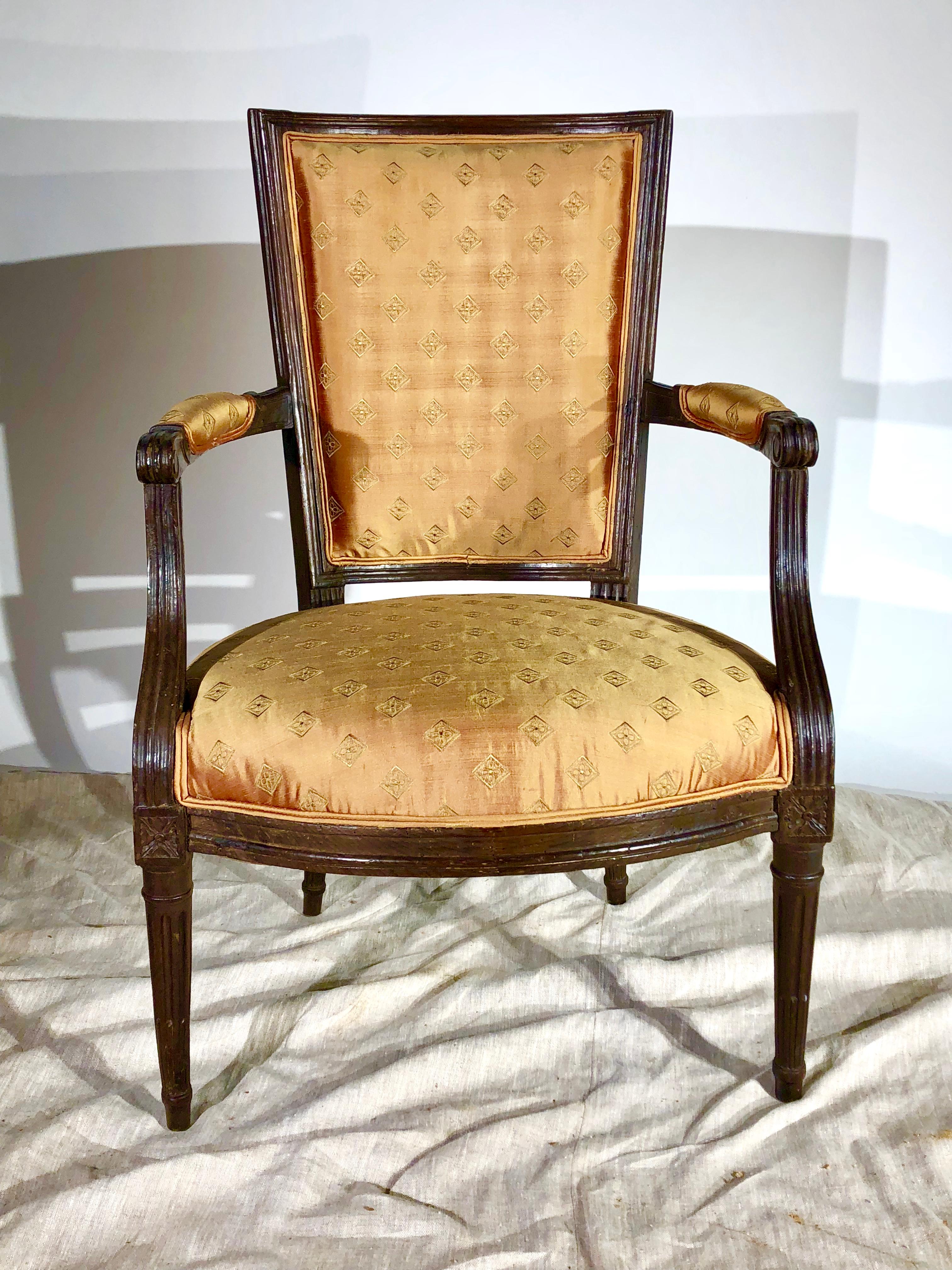 A French Louis XVI Period Fauteuil in stained beechwood, with silk upholstery, circa 1790.