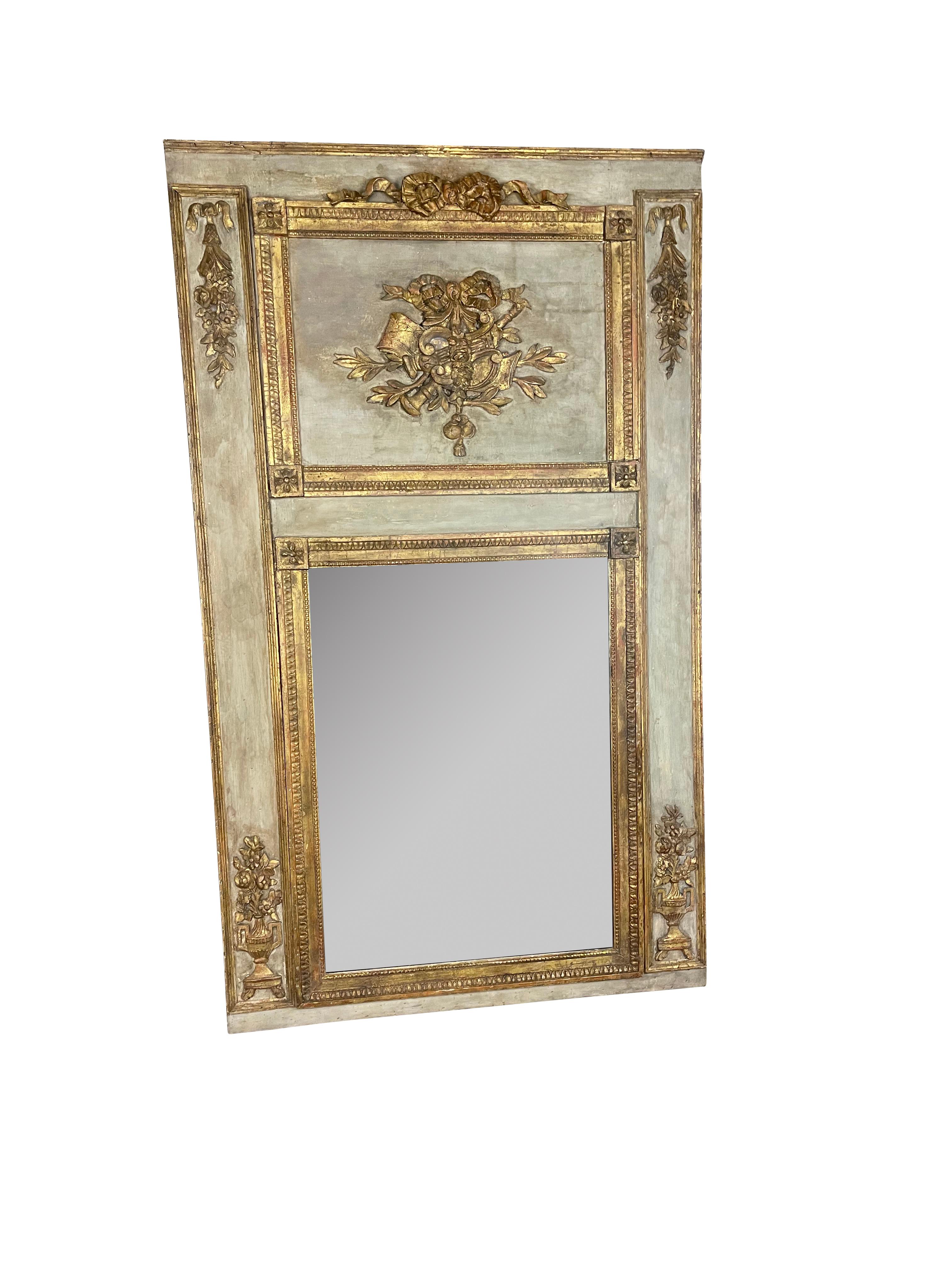 One of the most beautiful period Louis XVI Trumeau mirrors I have come across. A large French Louis XVI period painted trumeau mirror from the late 18th century, with carved giltwood flowers, garlands, and bows. Born in France during the reign of