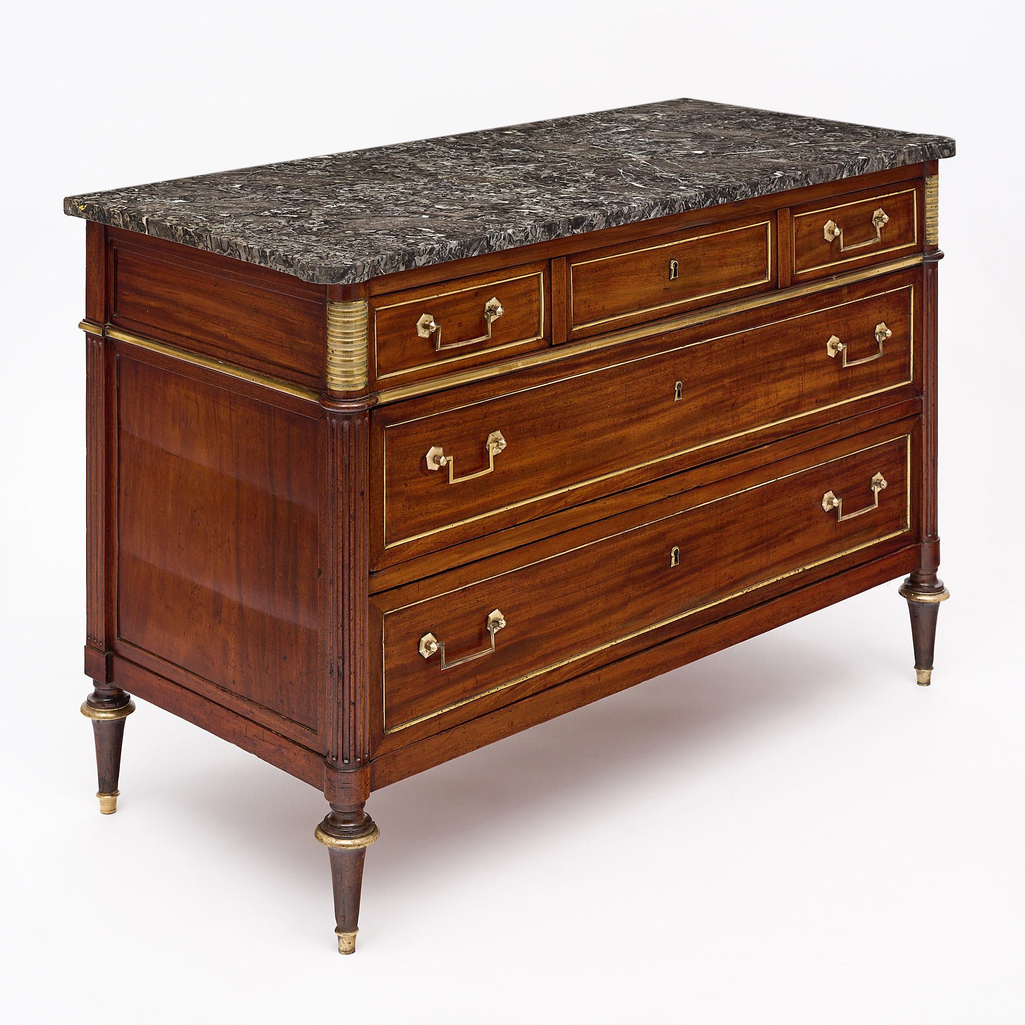 Chest of drawers, commode, French, Louis XVI period, of figured mahogany, five dovetailed drawers, oak as a secondary wood, gilt brass and hardware throughout. The chest is finished in a lustrous French polish and features an intact “Sainte Anne