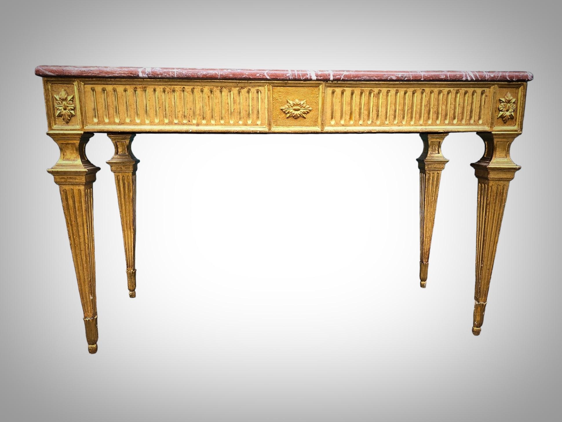 Step into the grandeur of the Louis XVI era with this magnificent console table crafted from gilded and carved wood. Dating back to the late 18th century, this exquisite piece epitomizes the elegance and sophistication of the period.

The console