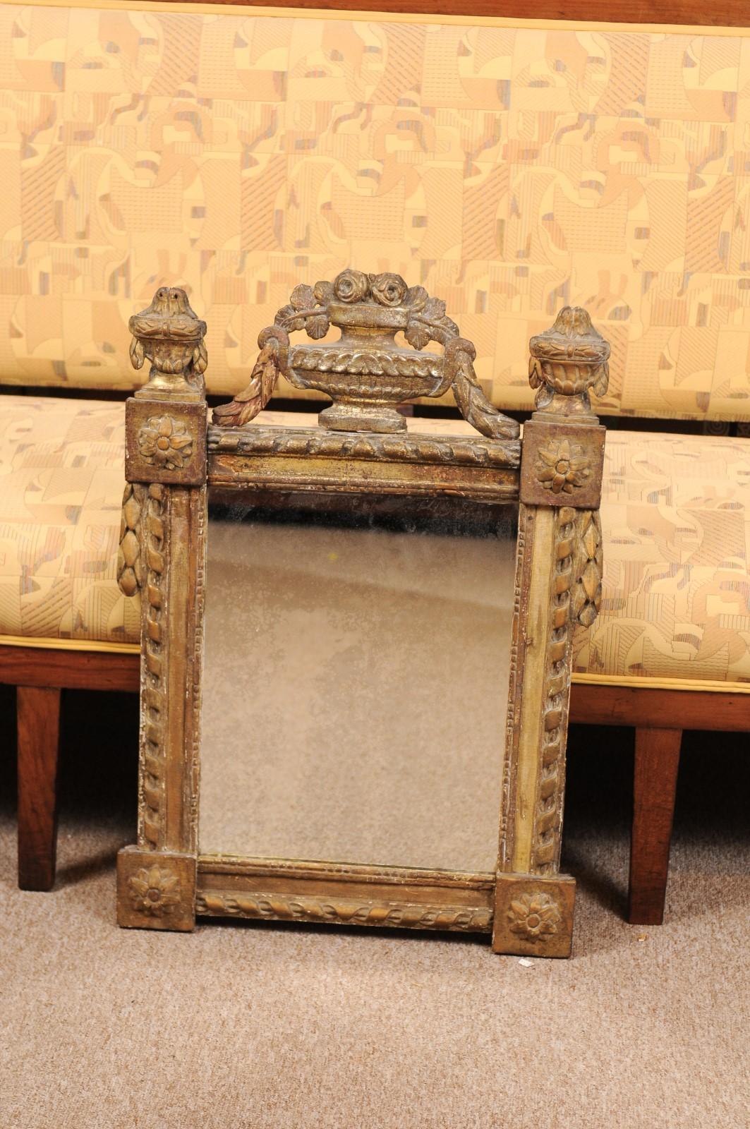 Late 18th century French Louis XVI period giltwood mirror with urn crest.