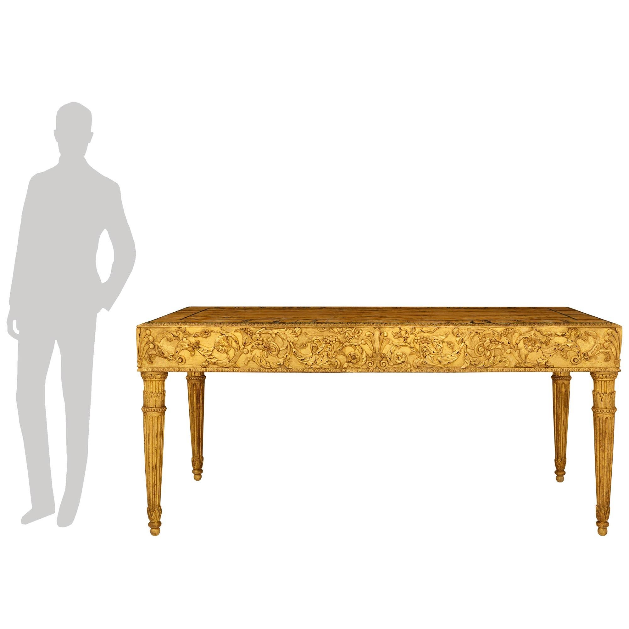 Una sensacional mesa de centro italiana de finales del siglo XVIII del Periodo Luis XVI de madera dorada, siena y mármol Vert de Patricia. Esta excepcional mesa se eleva sobre cuatro patas circulares estriadas y ahusadas, diseñadas en forma de