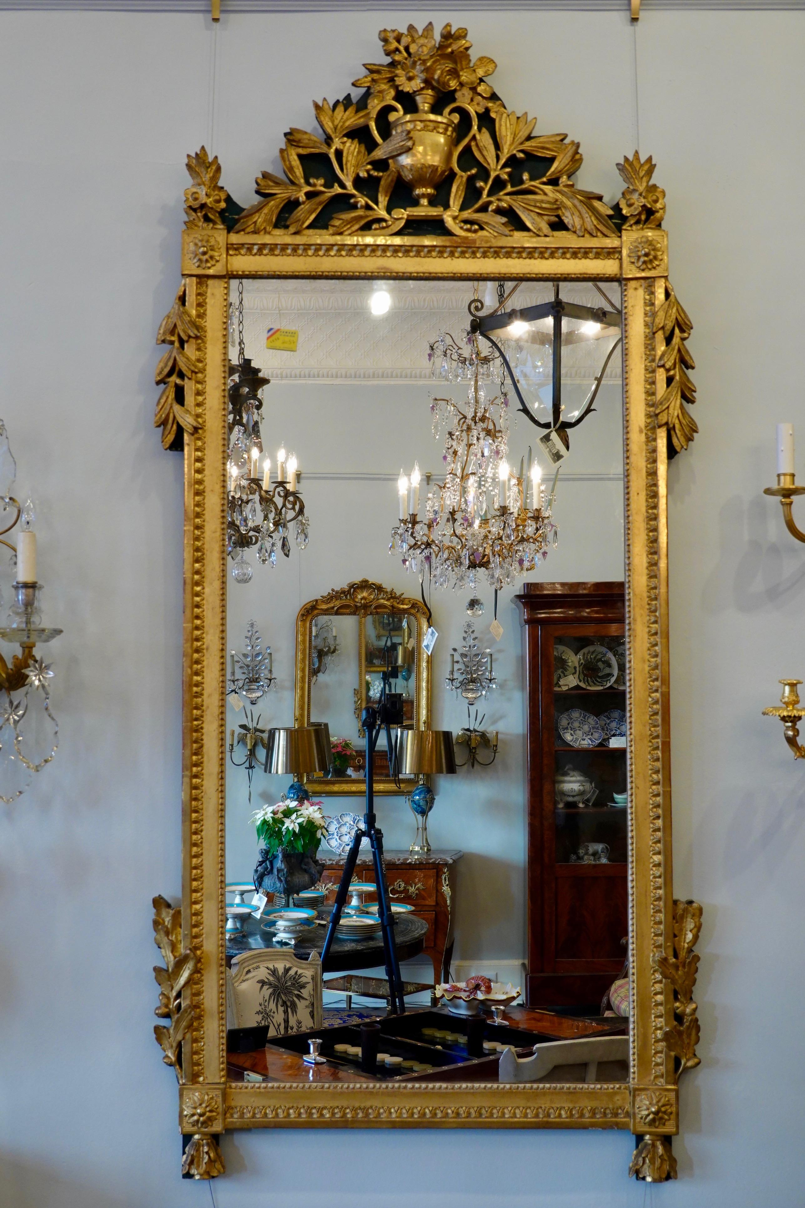 Grand miroir trumeau français en bois peint et doré, avec belle dorure d'origine, décoration néoclassique très détaillée (période Louis XVI, vers 1780) ; le verre est plus tard. Le miroir présente un cartouche représentant une urne avec une gerbe de