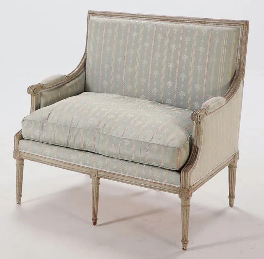 An 18th century Louis XVI period Marquise (wide bergere) in original cream-colored painted finish, with a simple square upholstered back, upholstered arms and sides, with a down-filled cushion seat, all on tapered fluted legs.  Currently upholstered