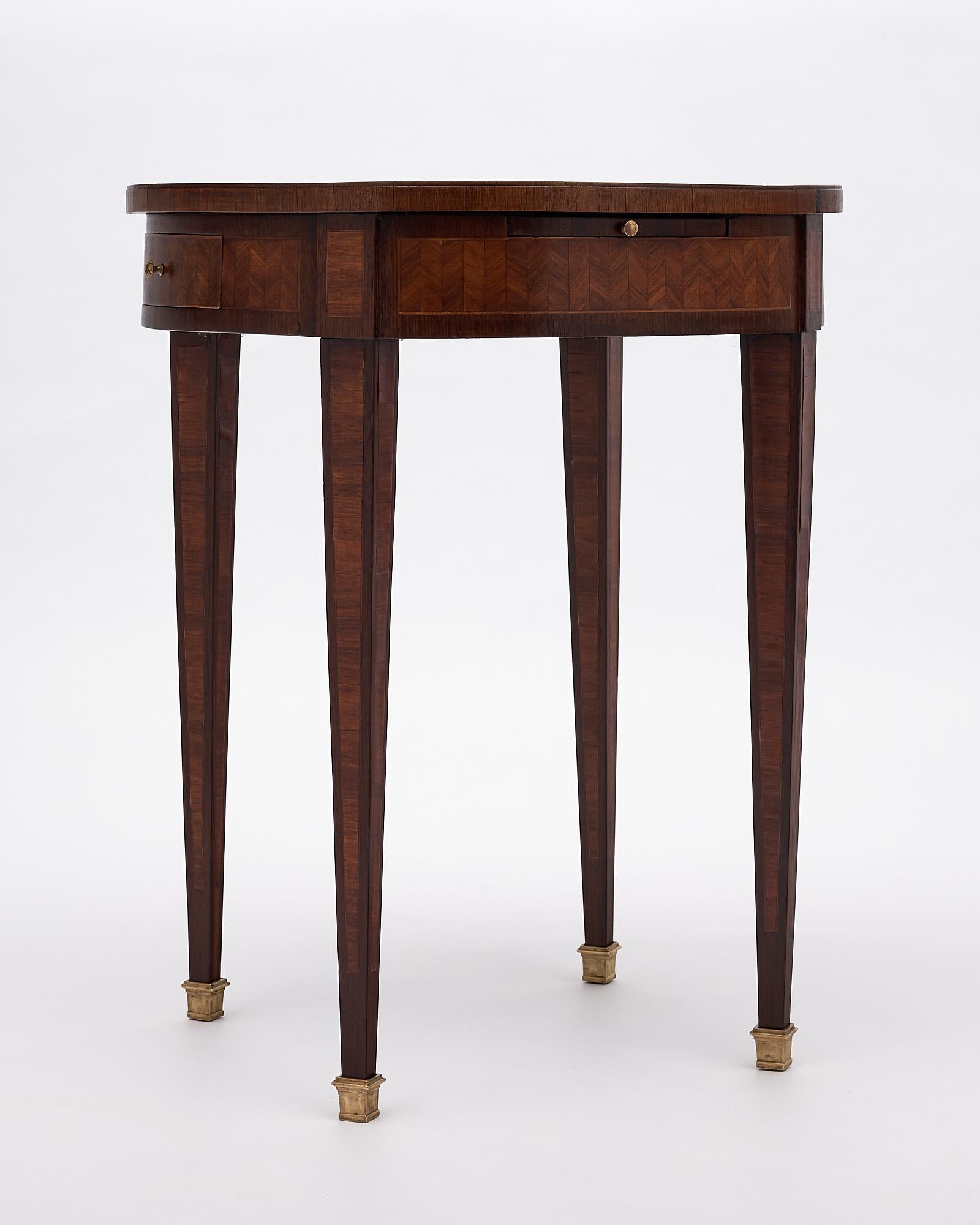 Table, “bouillotte”, French, made of rosewood with a beautiful, intricate parquetry work on the top and apron. There are two drawers and two tablets. It is finished in a lustrous museum quality French polish and is supported on brass feet.