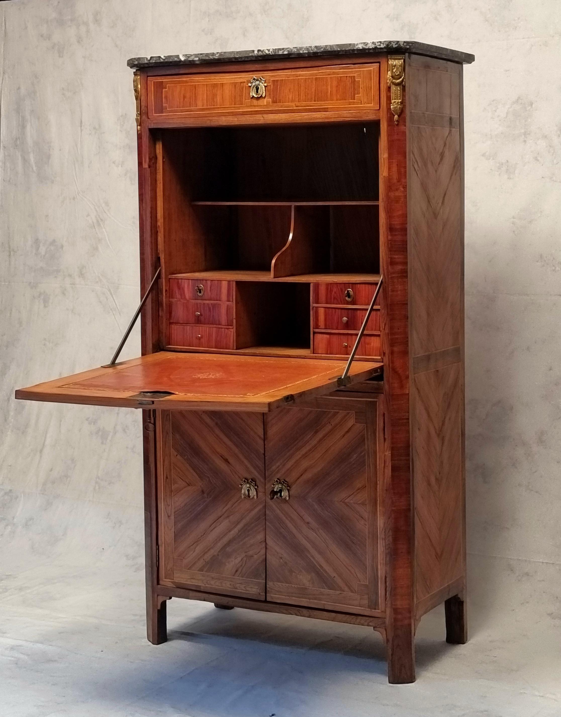 Magnificent secretaire with flap from the Louis XVI period from the end of the 18th century. It has a magnificent curling work (marquetry) giving a beautiful cross appearance on the rosewood front and rosewood frame. The flap discovers a box made up