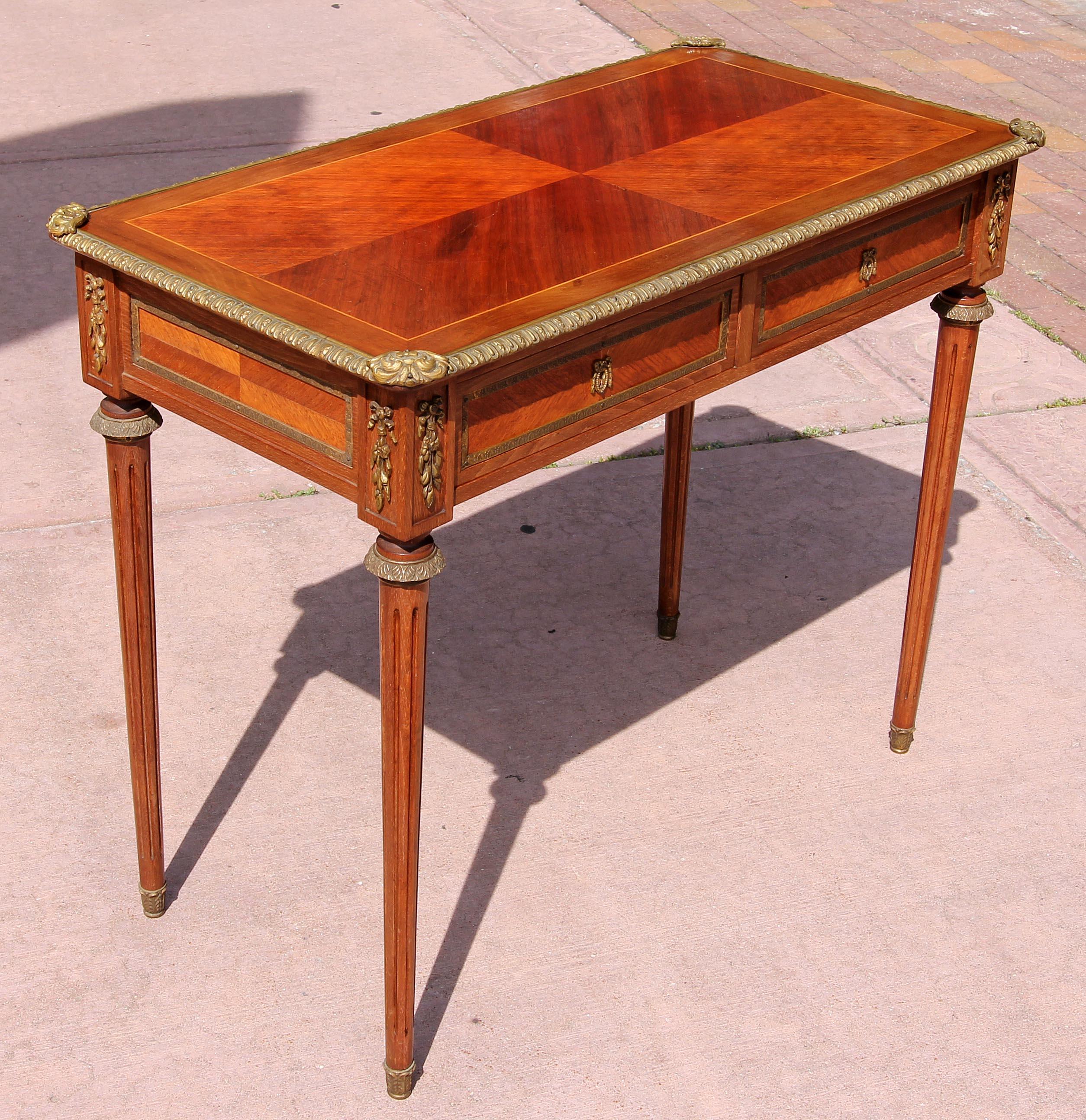 French Louis XVI style petite two drawer desk or console. Walnut and beechwood with brass mounts, circa 1920s. Contact us for possible shipping options.