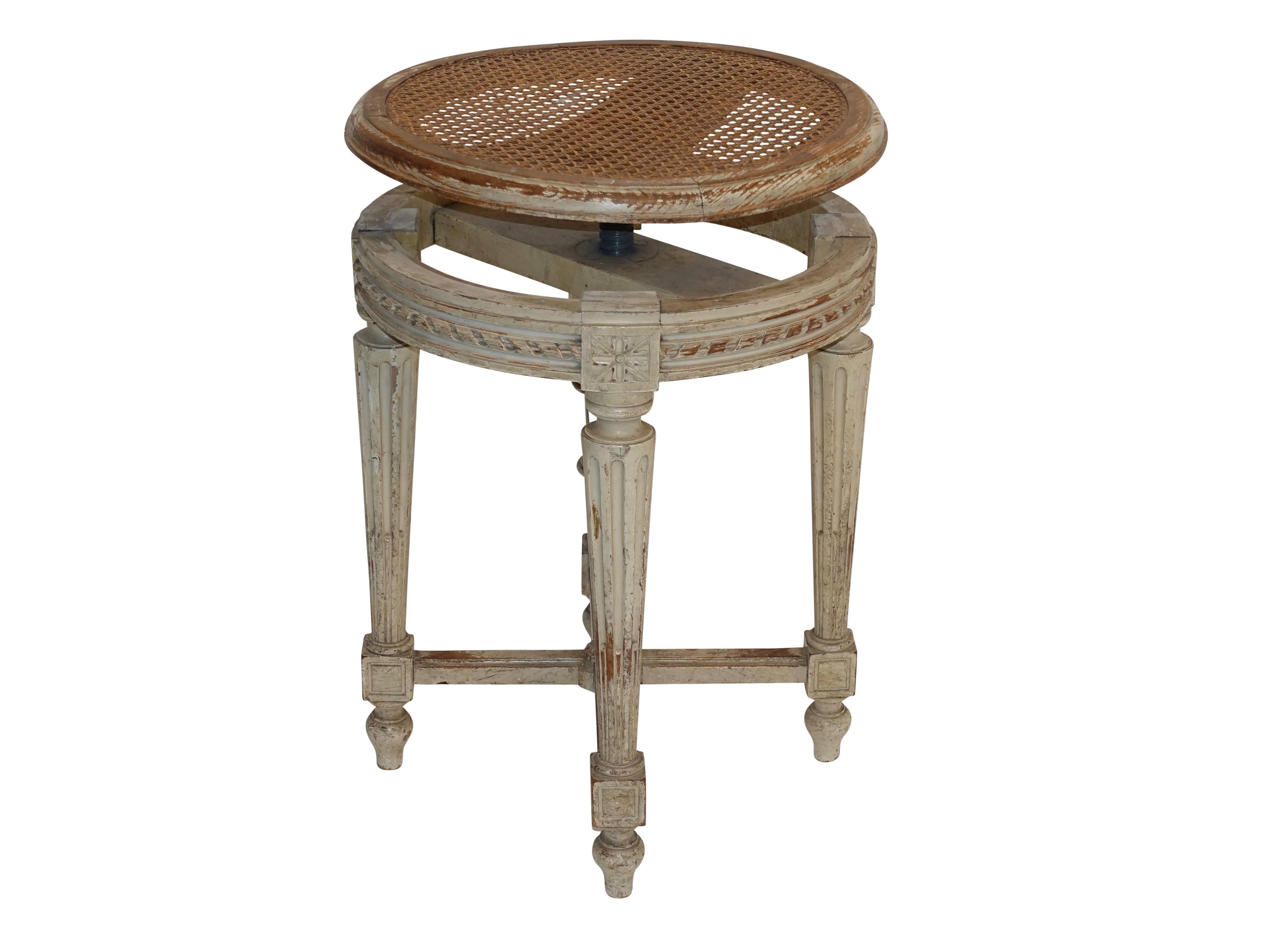 Louis XVI piano stool with original paint and original caned seat. The seat adjusted to its highest point measures 24 inches, France, circa 1880.