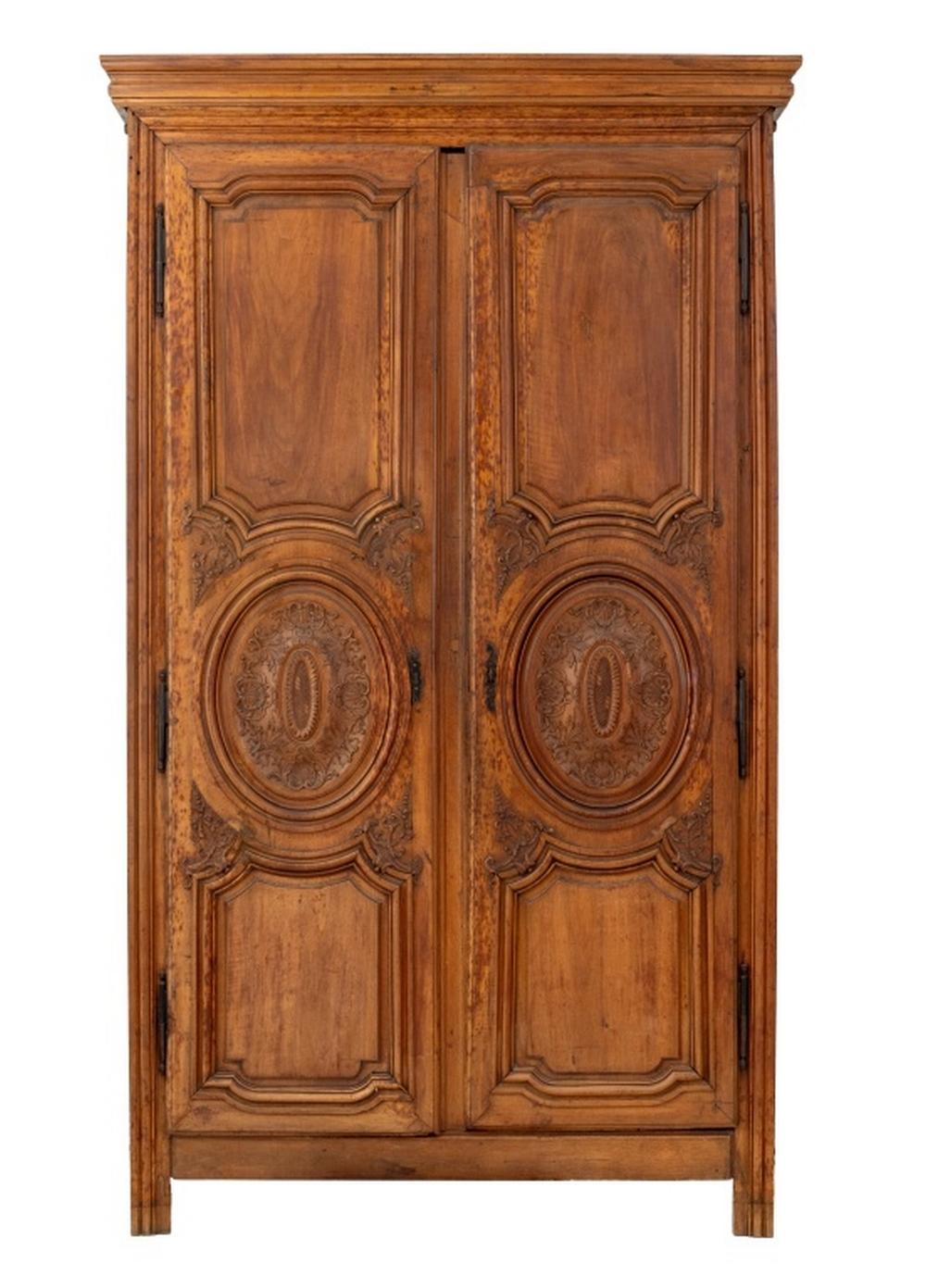 Armoire provinciale Louis XVI, en noyer, avec des rondeaux oblongs sculptés et une corniche à fronton. L'intérieur est divisé en deux étagères de chaque côté. 92
