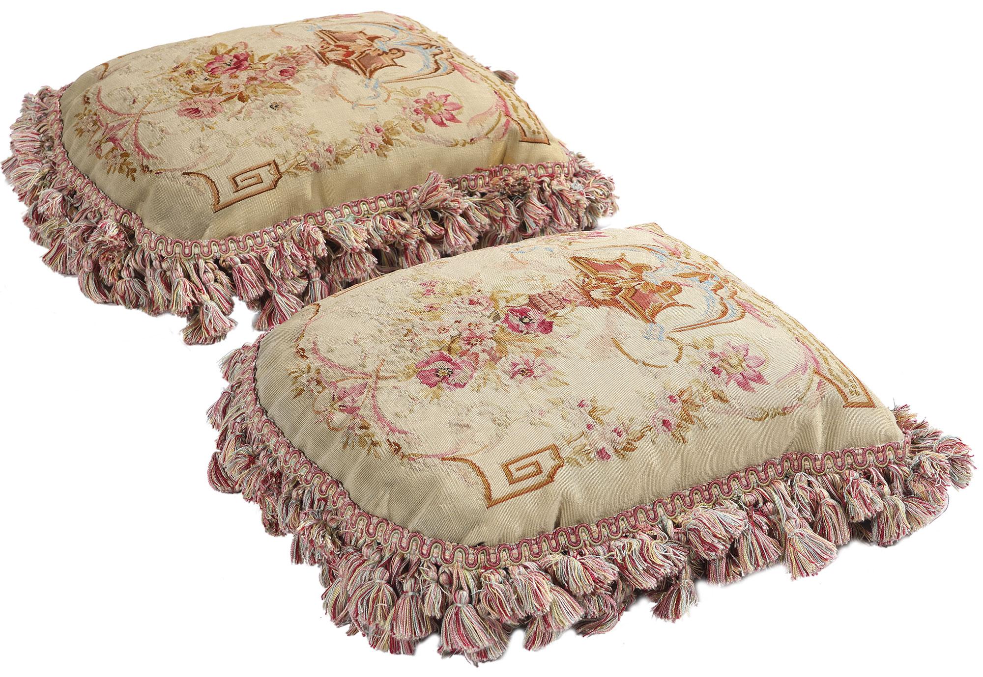 79197 Paire de coussins Aubusson de la fin du 19ème siècle, 01'00 x 01'01 x 00'04. Faisant doucement écho aux chuchotements raffinés des intérieurs de la Belle Époque, cette paire enchanteresse de coussins en tapisserie d'Aubusson ancienne en laine