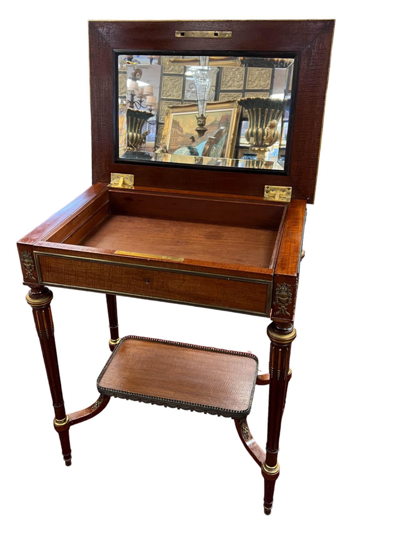 This late-19th-century flip-top dressing table—also known as a table de toilette, and sometimes functioning as a small writing or work table—combines elegant versatility with refined Neoclassical design. Its compact scale and slender legs make it