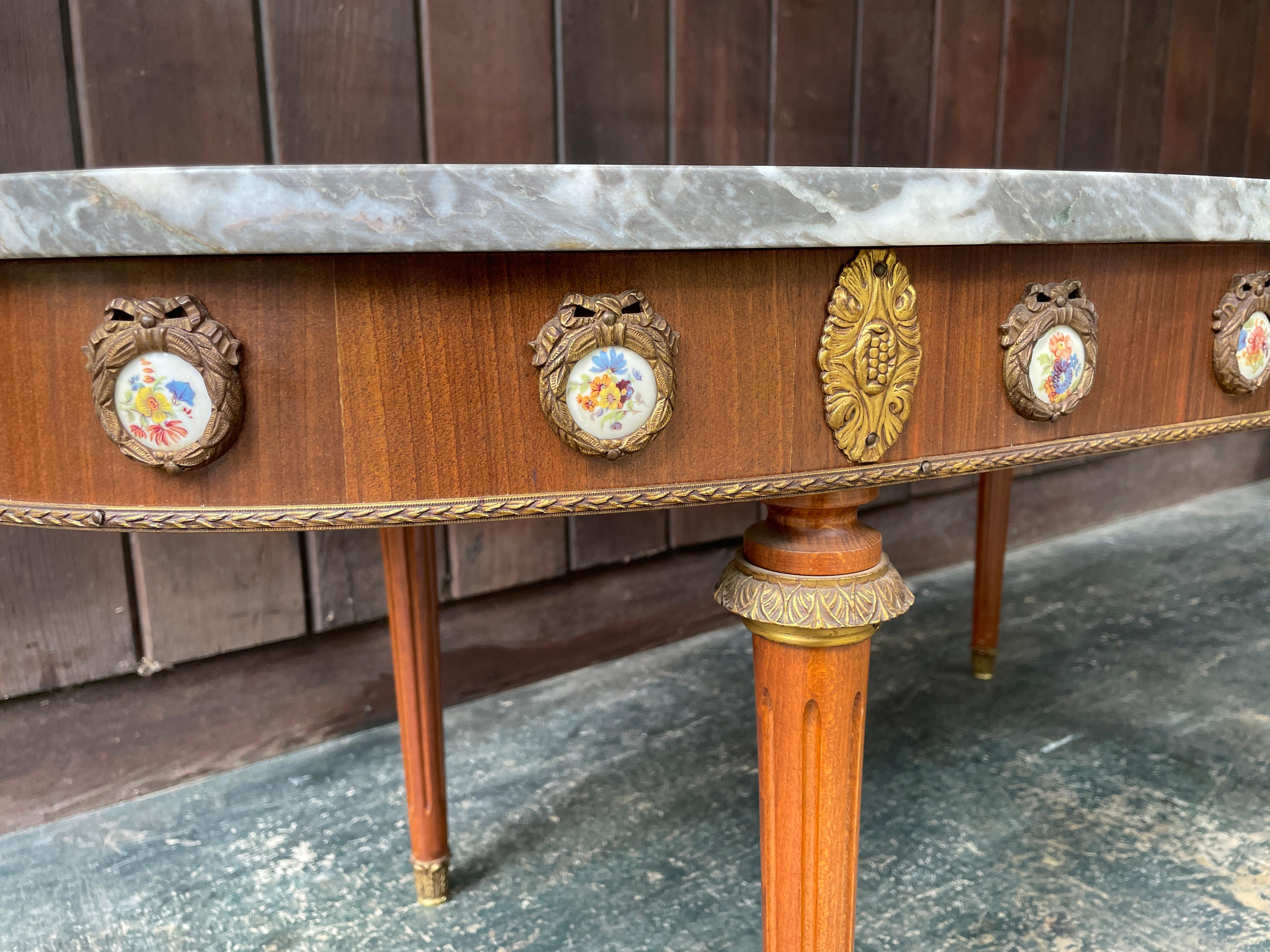 Mesa de centro ovalada de mármol de renacimiento Luis XVI con decoración de porcelana ormolu MCM mediados del siglo XX en venta