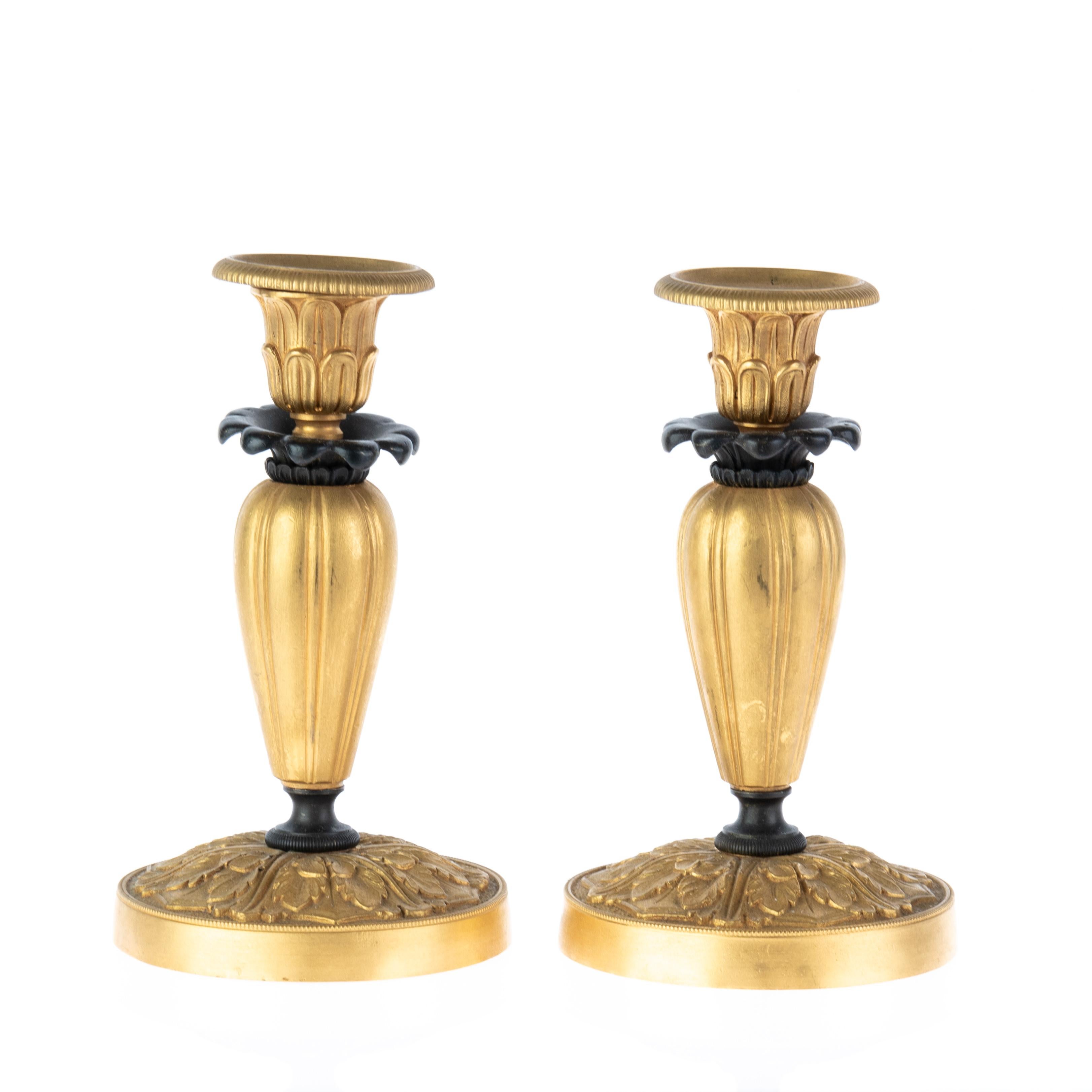 Este exquisito par de candelabros de bronce con acanto de estilo rococó del Renacimiento Luis XVI del siglo XIX es una impresionante representación de la elegancia neoclásica y la belleza intemporal. Cada candelabro, elaborado con gran atención al