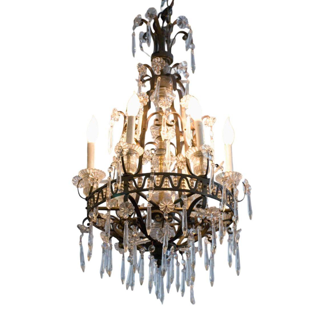 A breathtaking French crystal and bronze chandelier, adorned with delicate crystal flowers and cascading tiers of droplets. Featuring eight lights, this exquisite piece showcases a finely worked bronze frame with scrolling arms and intricate floral