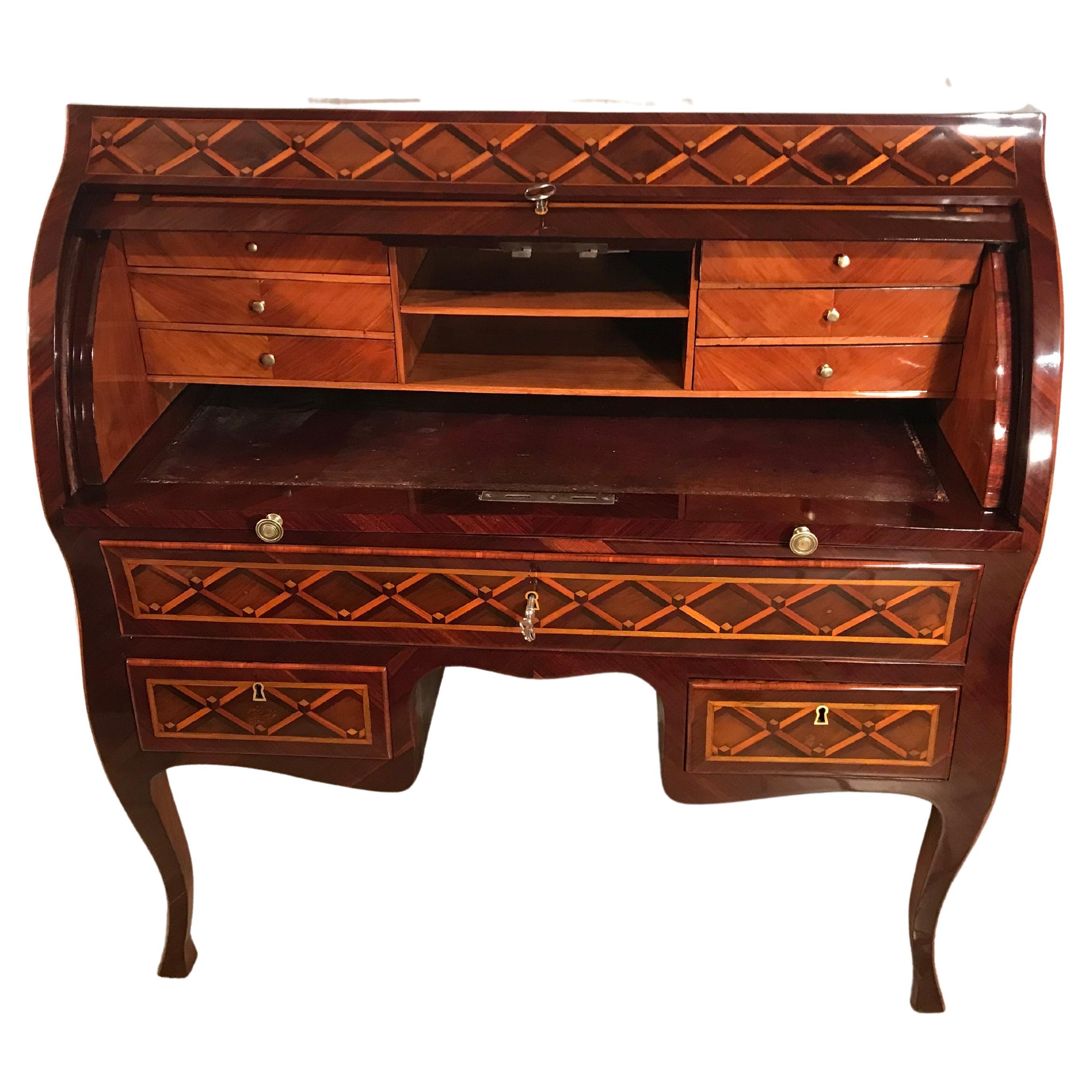 This unique Louis XVI Roll Top Desk was made in France around 1780. The outside of the secretary desk has a kingwood veneer with a gorgeous marquetry decor of diamond shaped yew wood inlays. 
The writing surface is covered with green leather. Inside