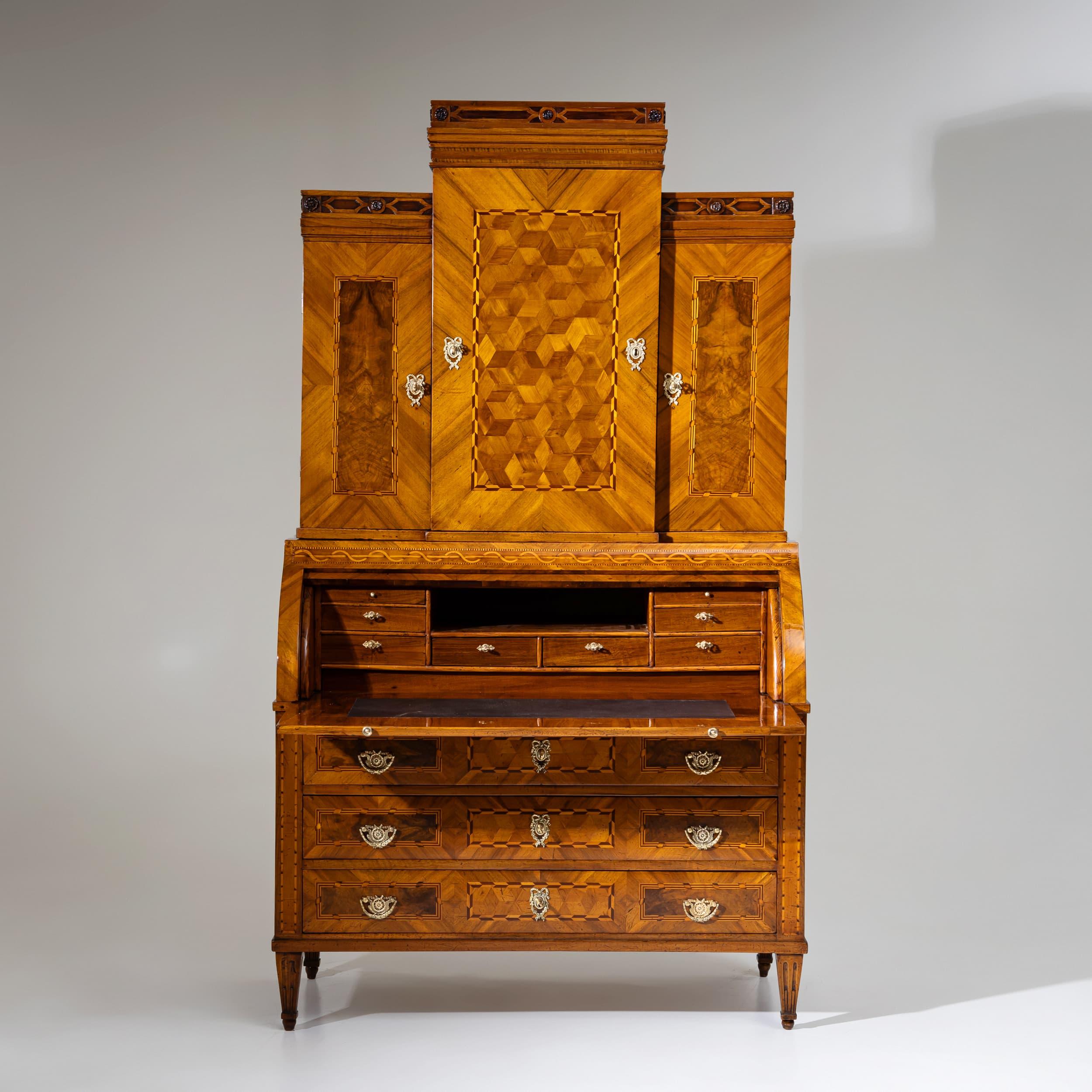 An elegant Louis XVI, Zopfstil, roll-top secretary desk, crafted in the late 18th century. The piece features a three-drawer base and a three-door upper section with a projecting central risalit. A surrounding gallery rail with delicate rosette