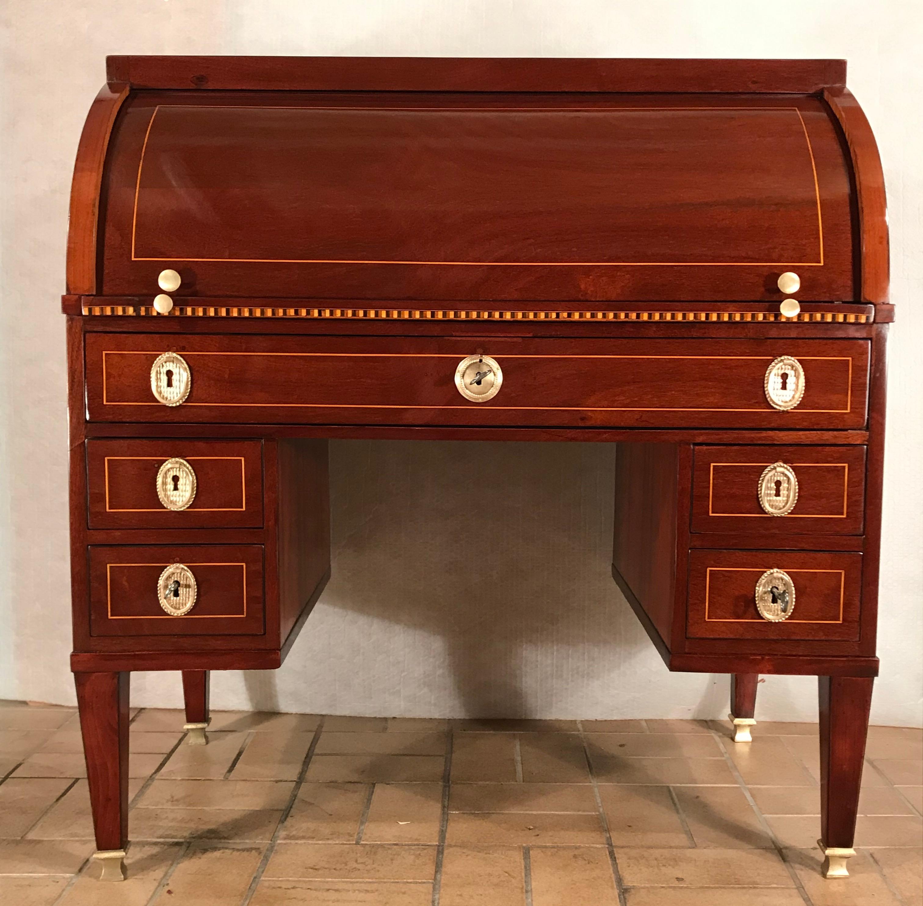 Louis XVI Rolltop or cylinder desk, France, 1780. This original Louis XVI cylinder desk has an elegant mahogany veneer with satinwood inlays. It has five exterior drawers. Behind the cylinder top are six small drawers and an open compartment. The