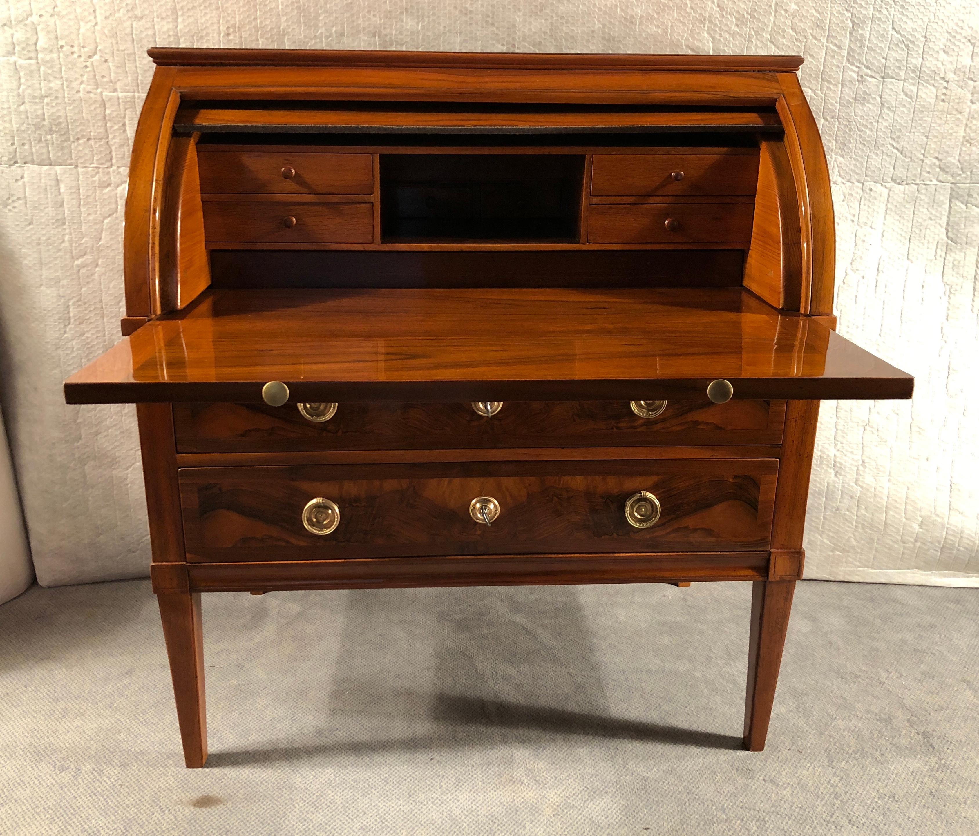 Exquisite Louis XVI Cylinder Desk, South German, 1780-1800, with beautiful walnut veneer on the outside and on the inside, including the writing surface. The outside of the roll top stands out for its mirrored burled walnut veneer. Original bronze