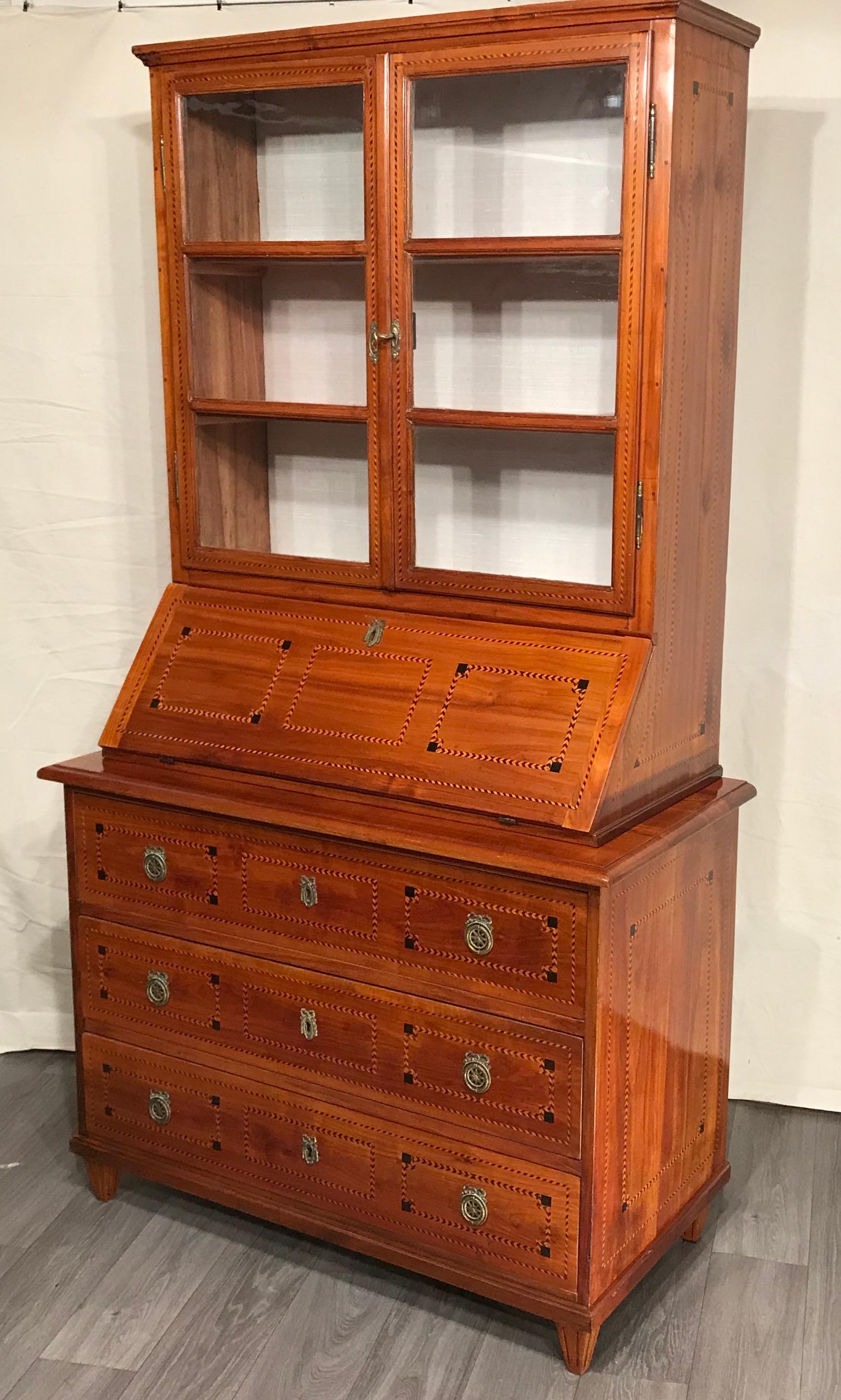 Louis XVI secretary bookcase, South German 1780.
Elegant and unique secretary bookcase with beautiful cherry veneer and Louis XVI style geometric inlays in king wood and maple. The lower part has three spacious drawers, the upper part has two glass