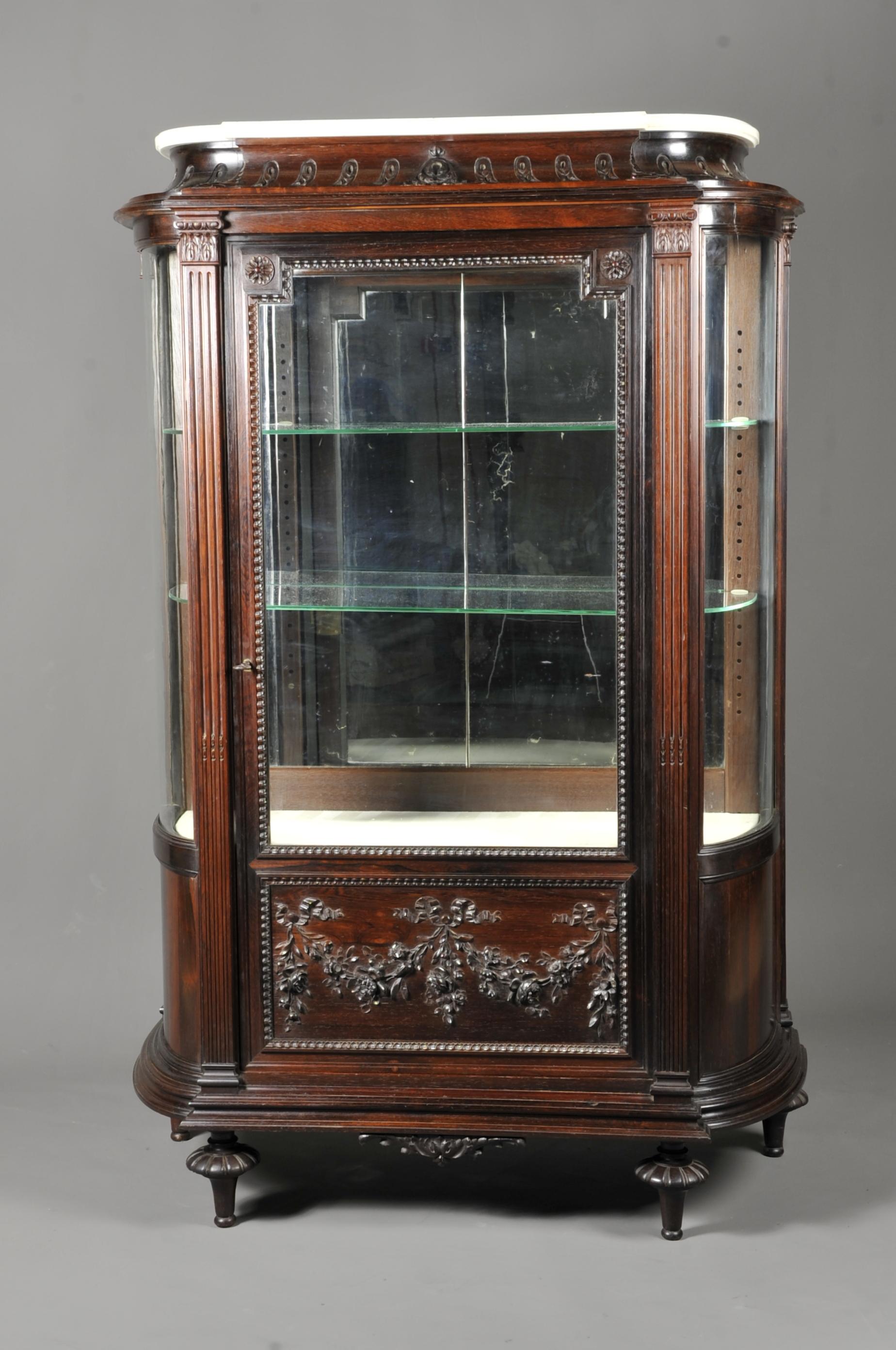 Rare Louis XVI showcase made of very finely carved solid rosewood. Opening a front door decorated with floral garlands and heart-shaped friezes, the sides are domed and delimited by two fluted pilasters ending in a neoclassical capital. In the upper