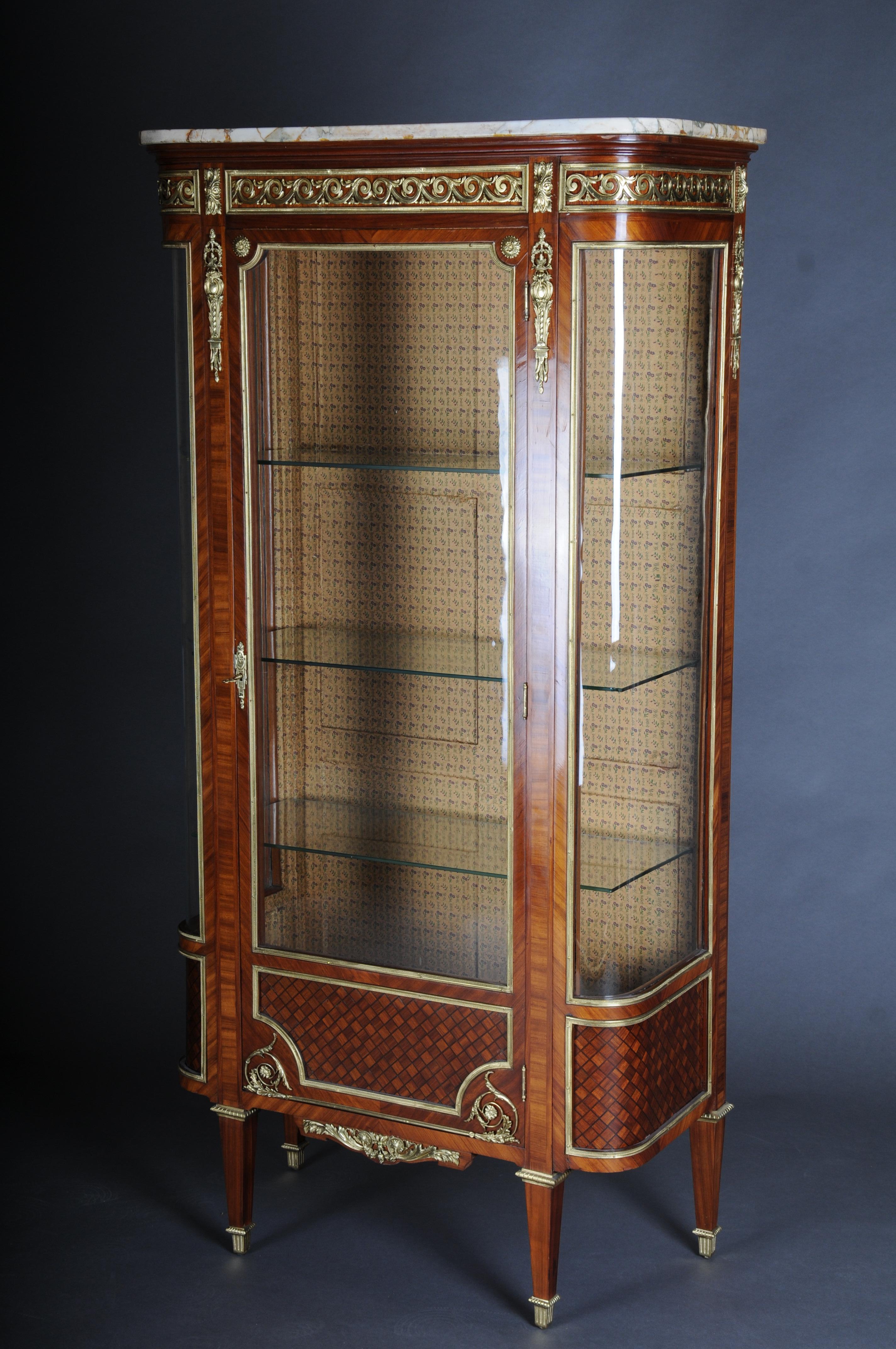 Louis XVI showcase Napoleon III, Paris around 1870.

Fine veneer on solid oak, veneered and paneled with ebony inlays. Straight, single-door body (solid oak) with white, grey-brown veined marble top. Three-sided glazing with rounded corners.