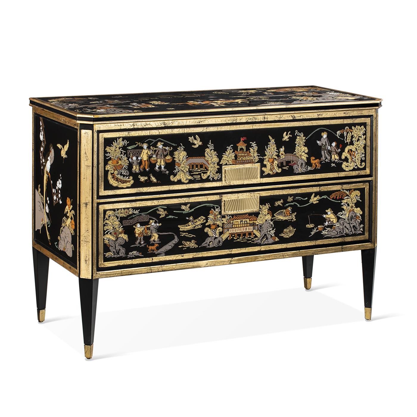 A fancy sideboard full of hand-painted decorations on glass with gold leaves and golden brass. It has 2 big drawers sliding on metal guides and then its front, sides, and top are heavily decorated giving a spectacular and majestic vibe to any room.