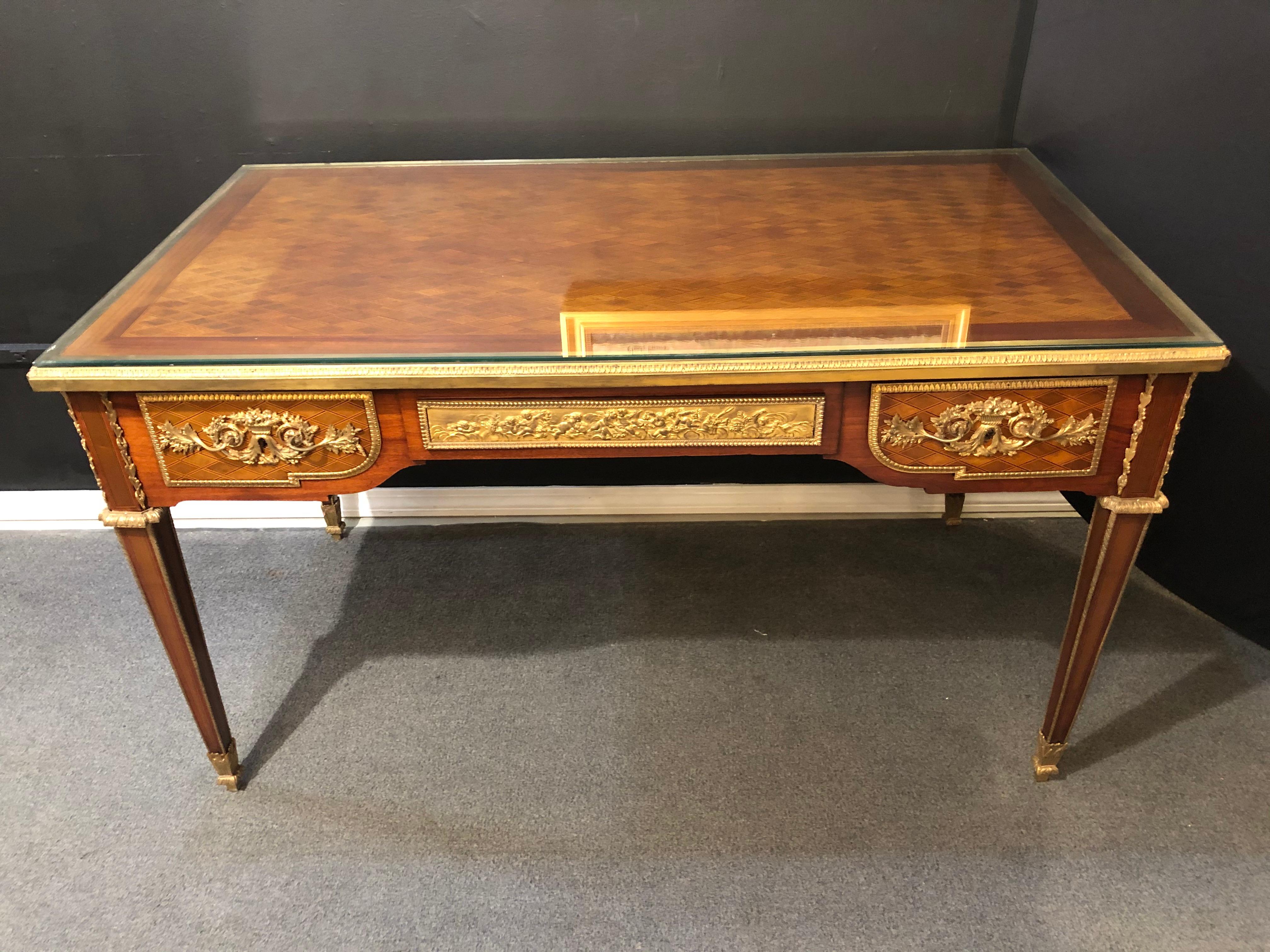 Louis XVI style 19th-20th century bronze mounted desk manner Linke. This spectacular French desk can sit center room as it is finished on all sides with its stunning parquetry inlays and bronze mounts. The table top covered in a beveled glass.
ES
