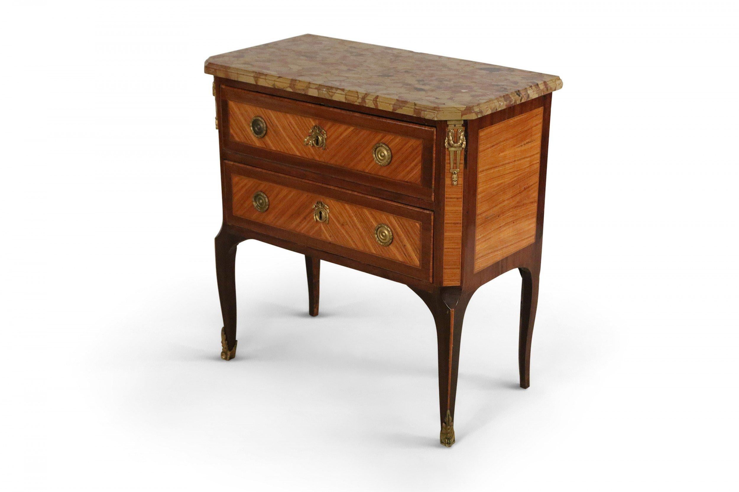 Louis XVI-style (19th century) commode with parquetry veneer, a beige marble top, two drawers with brass hardware, and bronze corner embellishments.