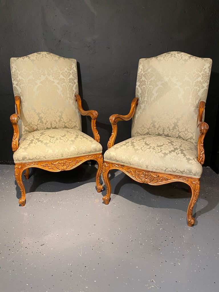 Louis XVI style antique arm, Throne chairs finely upholstered. A pair of stunning finely carved walnut framed and custom upholstered Throne chairs. Seemingly fit for a king and a queen are these clean and sharply upholstered chairs. 
 