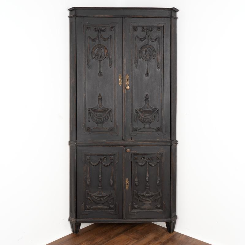 In person, it is the detailed carving in each section of this Louis XVI style oak corner cabinet that captures one's attention. Please enlarge photos to appreciate the hand carved swags/ribbon garland, faces, urns, rosettes and more revealing the