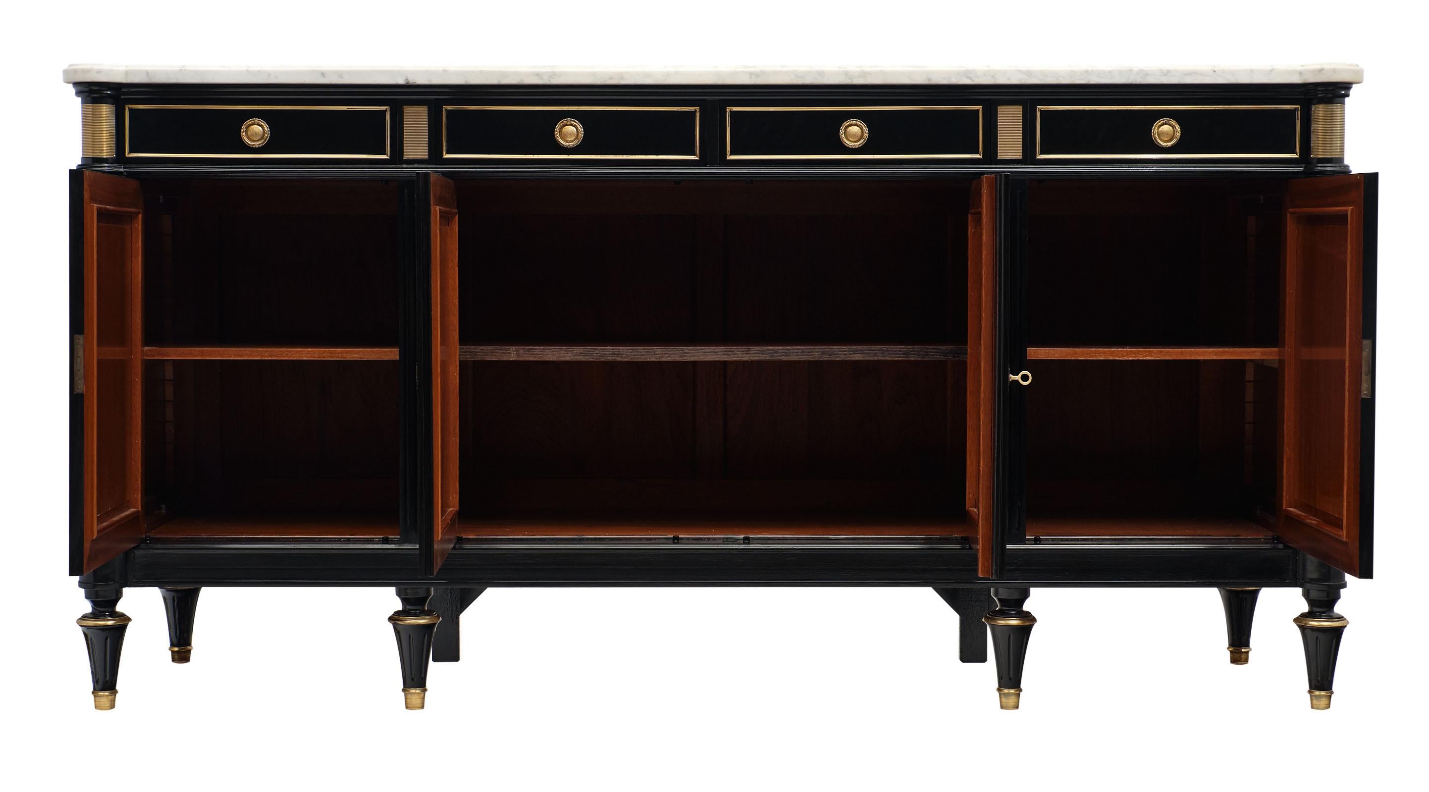 French antique Louis XVI style buffet / enfilade made of mahogany that has been ebonized and finished with a lustrous French polish. The marble slab from Carrara in Italy is original to the piece and intact. Gilt brass trims add a Classic touch