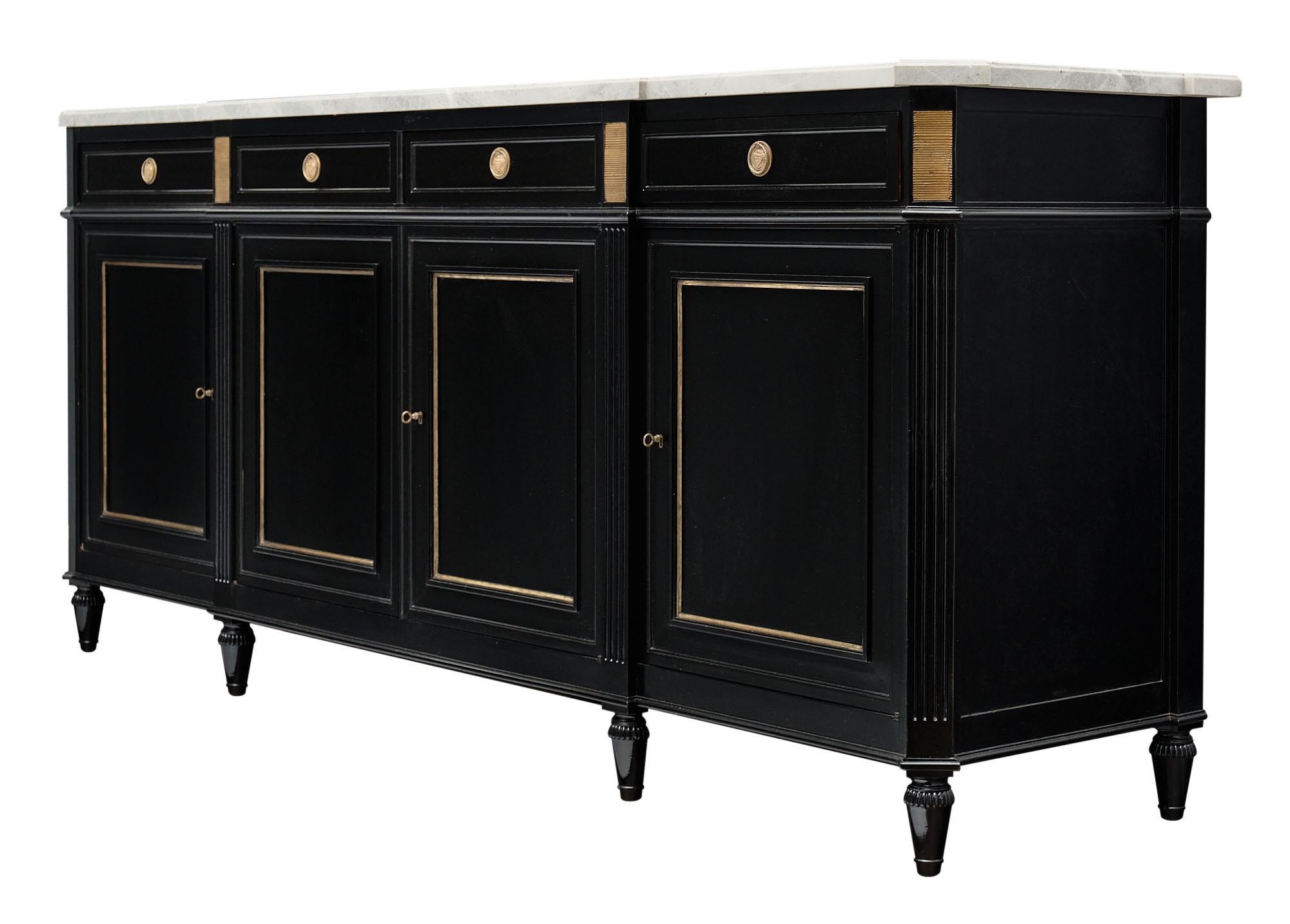 Louis XVI style antique French buffet made of mahogany and finished with an ebonized lustrous French polish. There is gilt brass hardware and trims throughout. The intact marble slab top has a beautiful gray tone and lovely veining throughout.