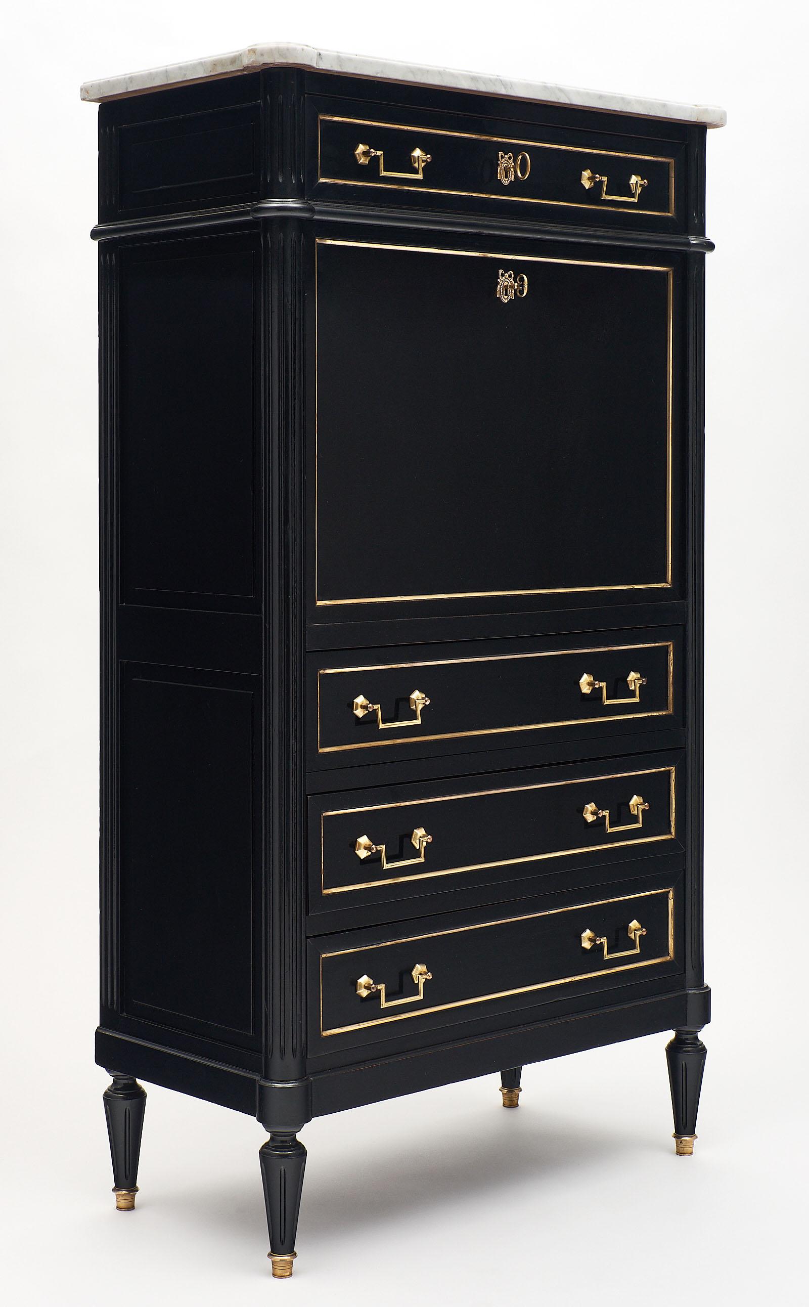 Antique Louis XVI Style French Secrétaire made of mahogany and finished with a lustrous ebony French polish. We love the Carrara marble top and original brass hardware and trim. There are four dovetailed drawers, the top of which locks. The interior