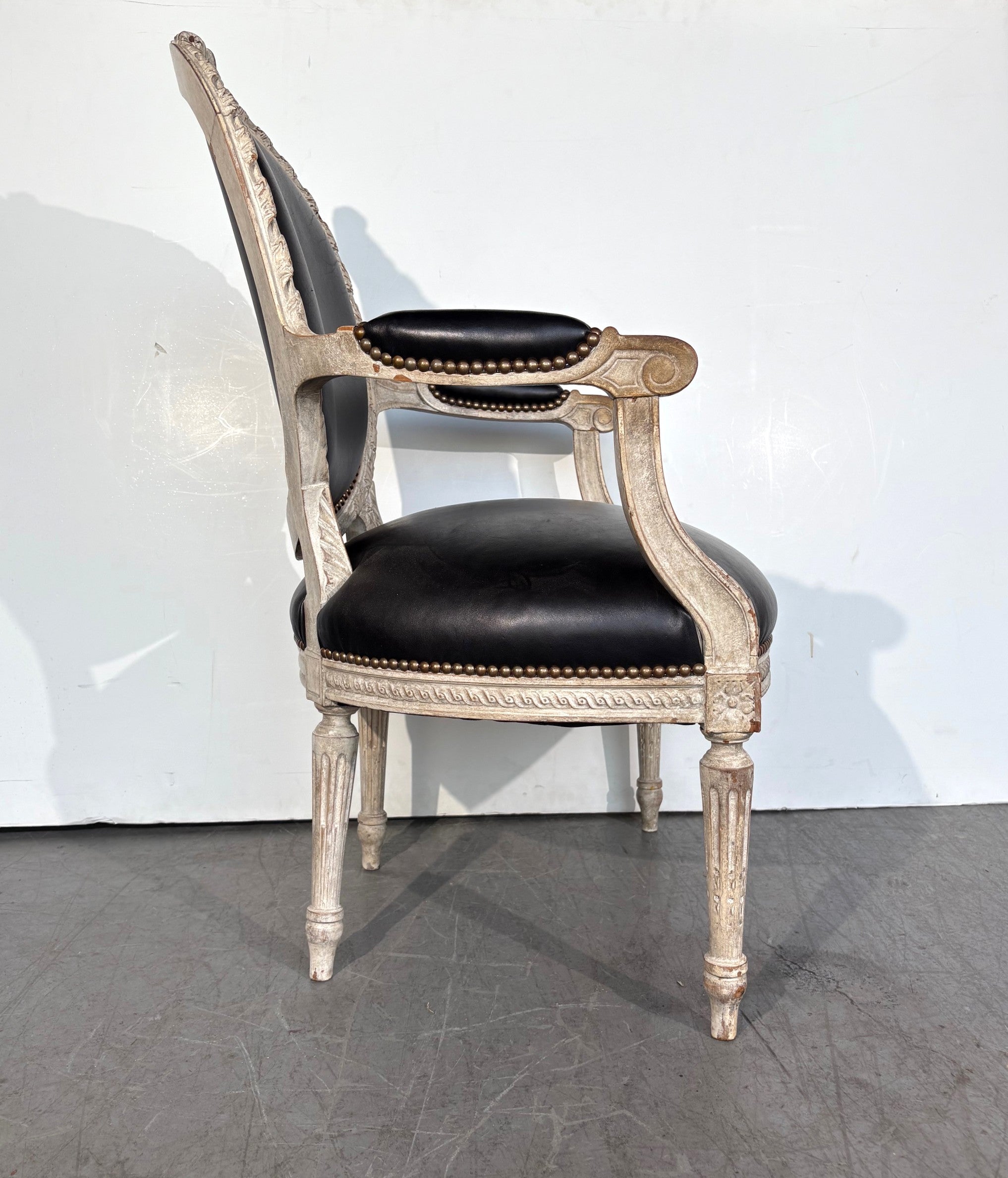 Sessel im Louis-XVI-Stil. Die Stühle sind mit schwarzem Leder und Nagelköpfen bezogen. 