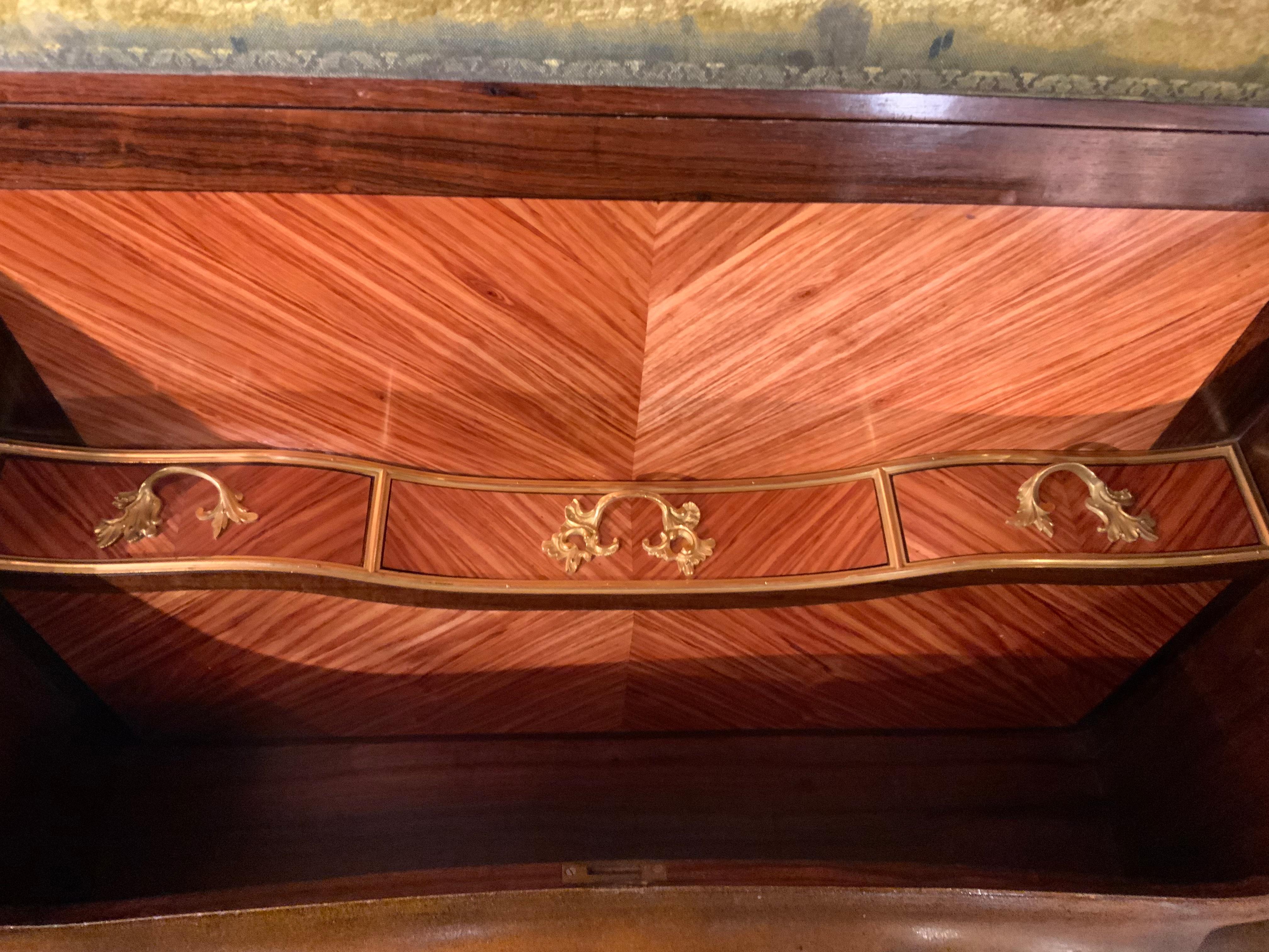 This piece is in the manner of Jacques Dubois , the shaped, rectangular top
Has a pierced three quarter pierced brass gallery above a slant front opening
To a storage well and drawers, raised on cabriole legs beaded by ormolu 
Mounts and ending