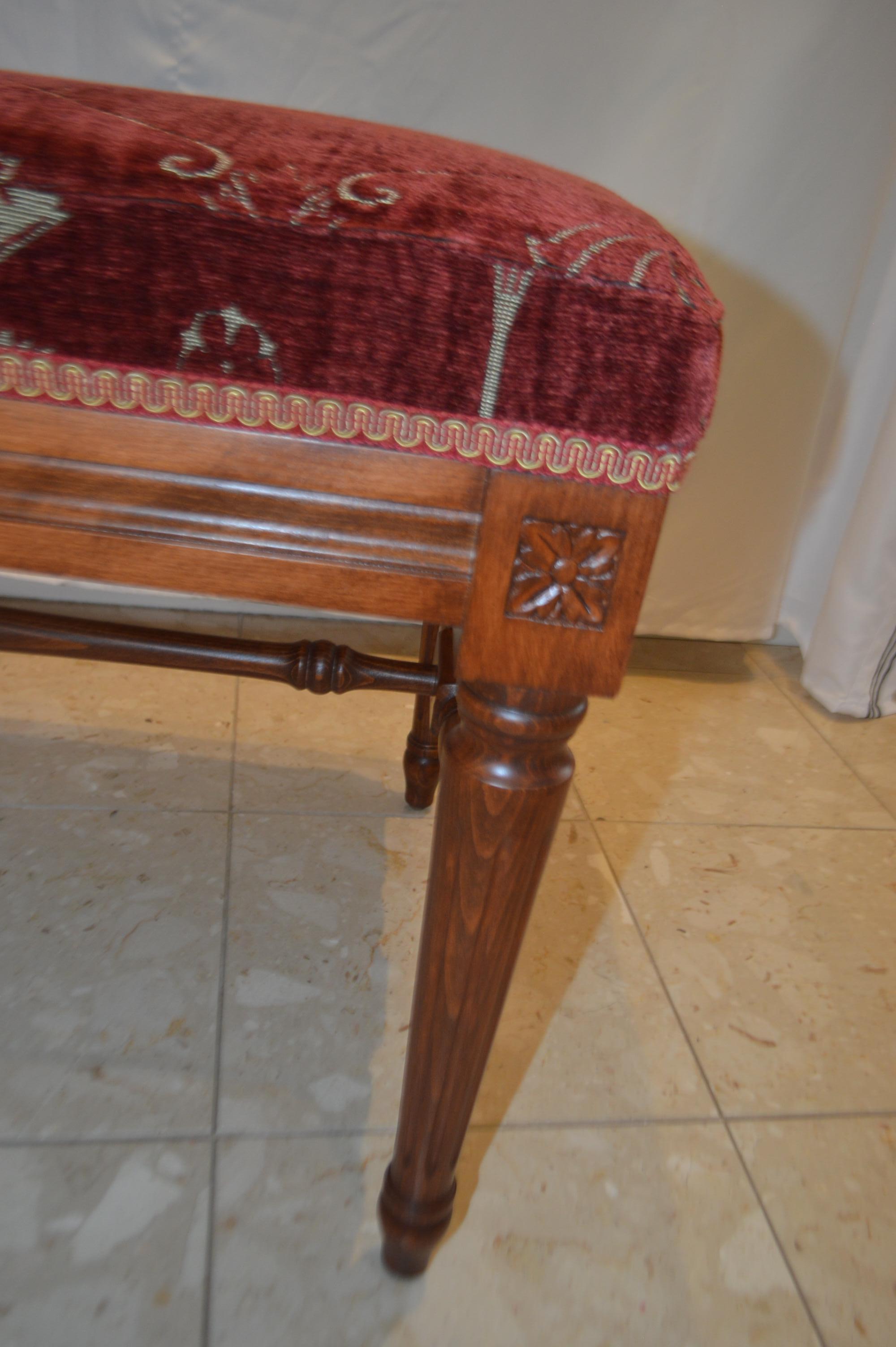 Louis XVI style bench made in Italy of beechwood and it has been stained in a walnut tone. The bench is made of fine quality having a center cross for stability and sturdiness. It has been upholstered in a rich red tone of a fine antique chenille