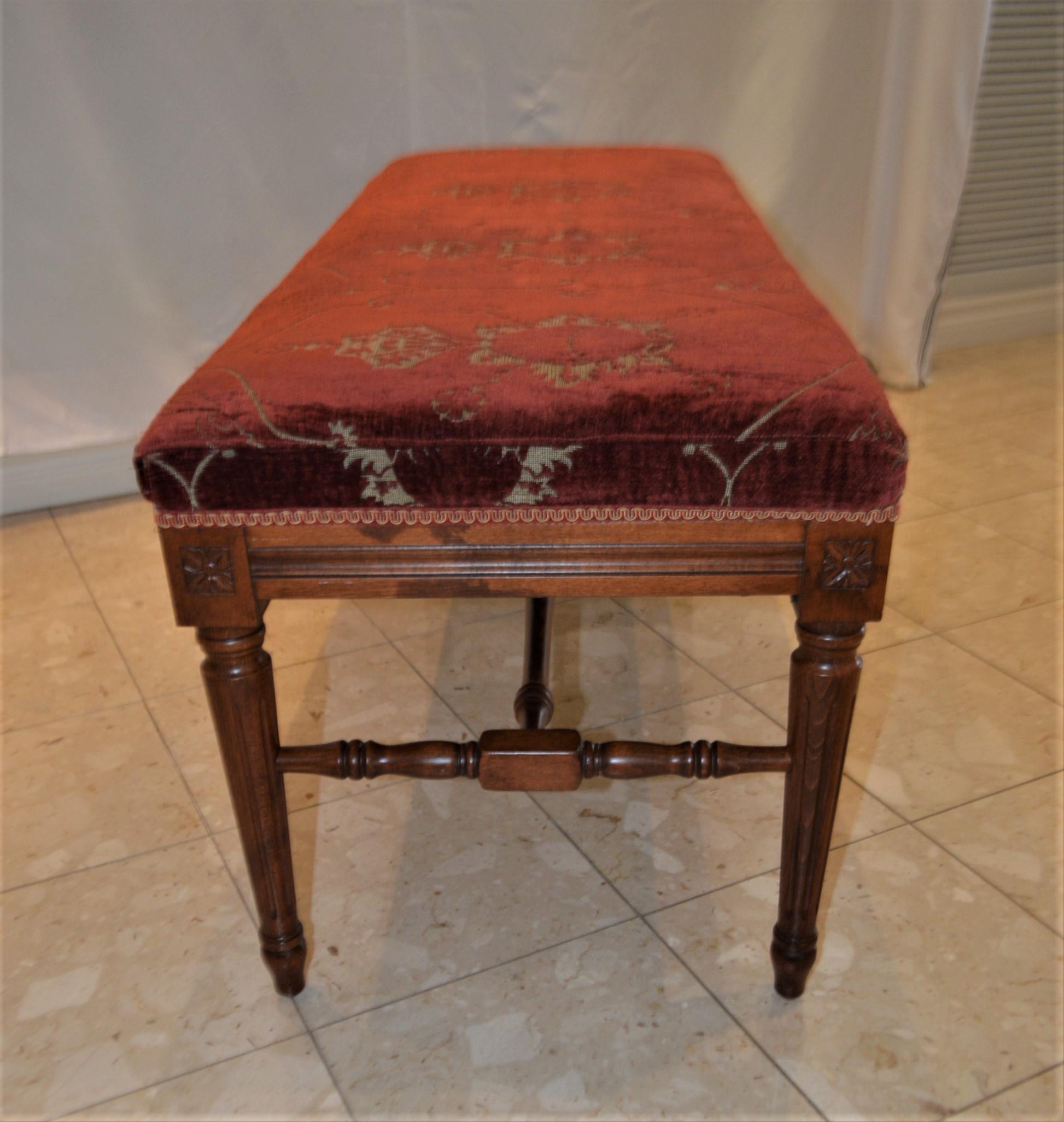 Stained Louis XVI style bench upholstered with a red antique chenille fabric.