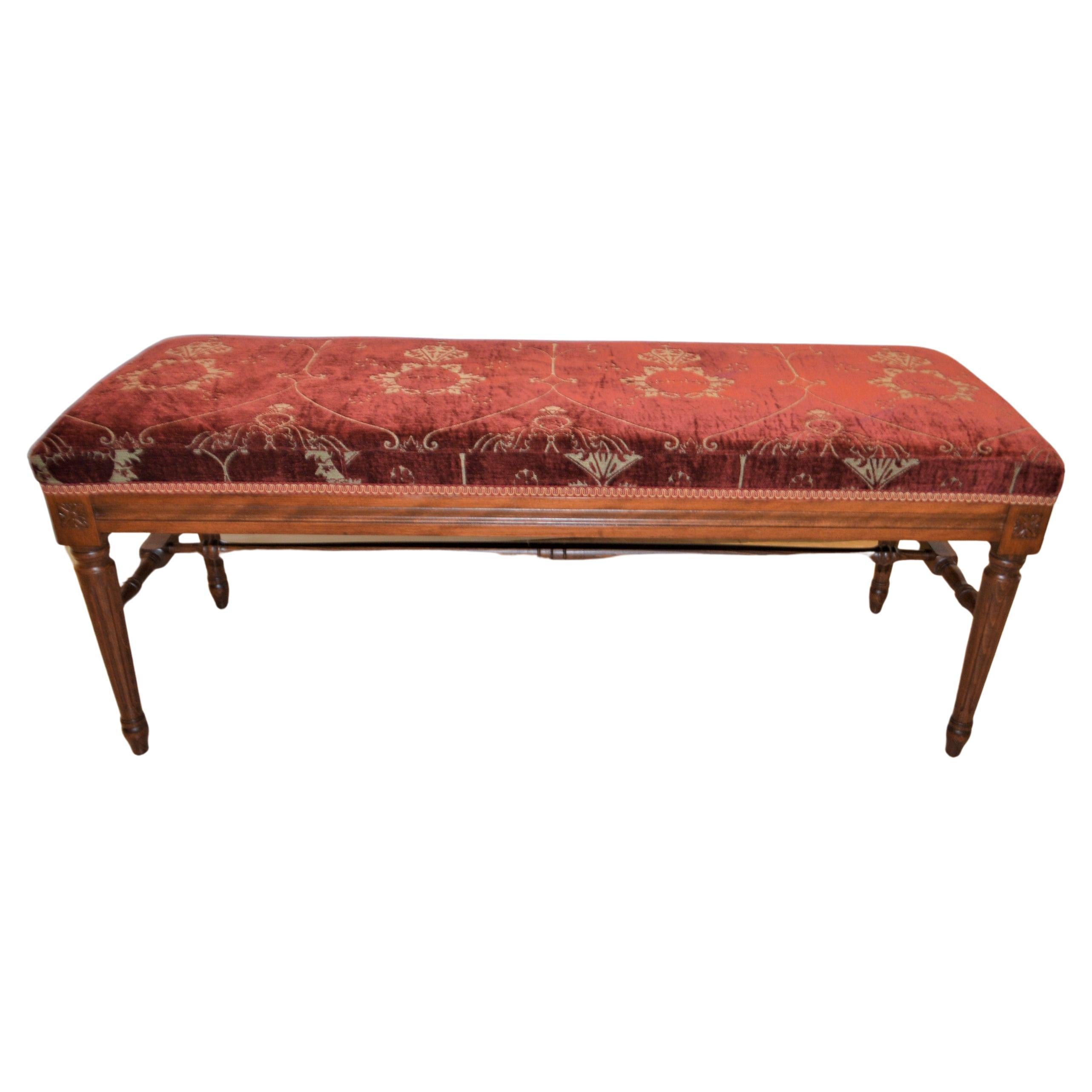 Louis XVI style bench upholstered with a red antique chenille fabric.