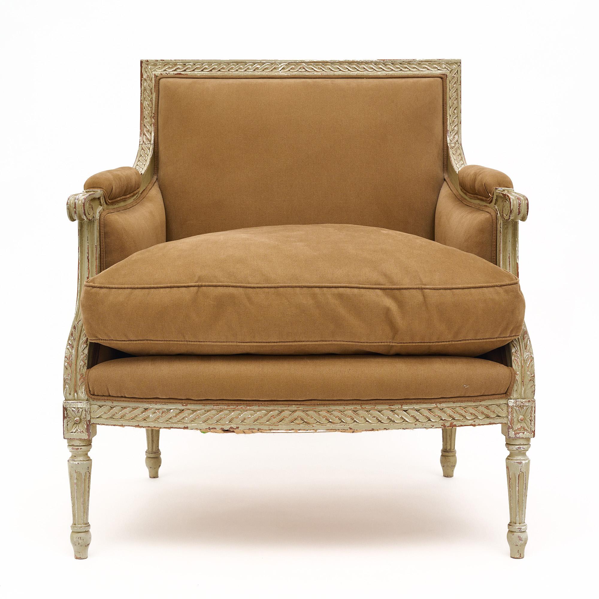 Single bergère armchair from France in the Louis XVI style. This piece has a hand-carved beech wood frame with original ‘trianon’ gray paint and patina. It is upholstered in a tan velvet in good condition. The classic proportions and detail make