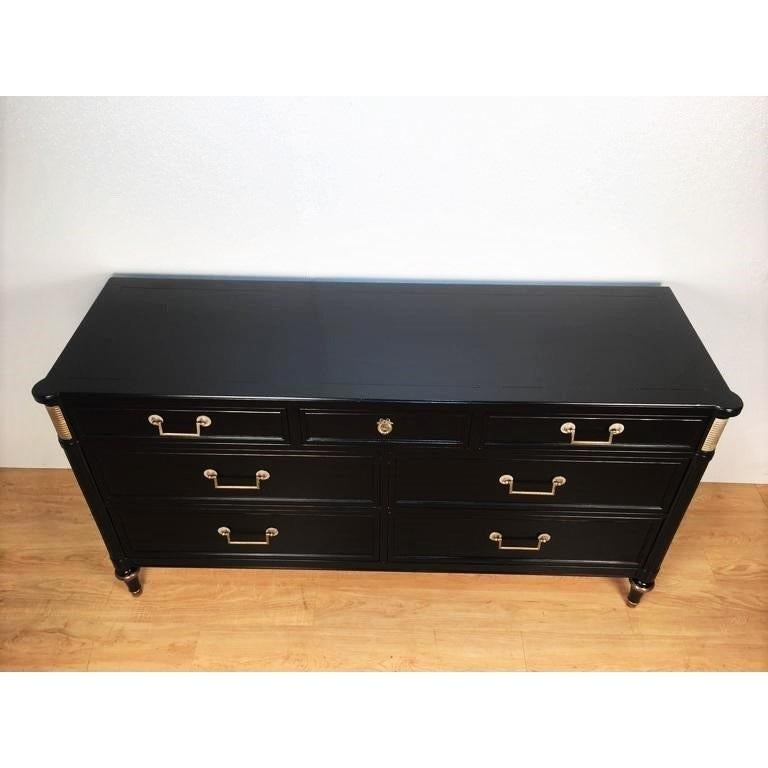 This is a stunning and decorative French Directoire style dresser or credenza in the manner of Maison Jansen. This chest sits on gilt trimmed sluted and tapered legs ending in brass caps supporting an apron leading to a case of seven drawers with