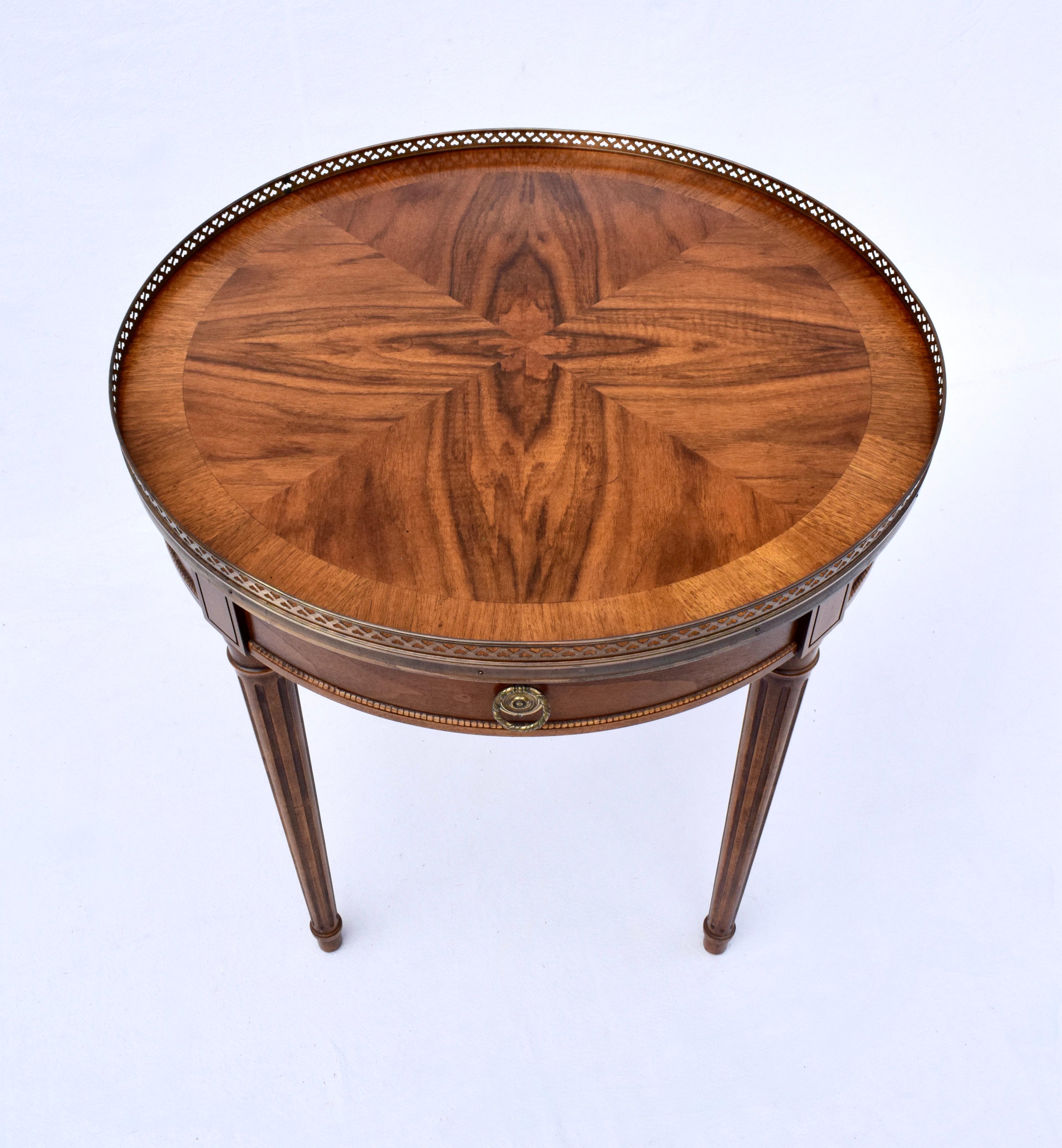 Table Bouillotte raffinée de style Louis XVI de Baker Furniture, délicieusement travaillée dans des grains de noyer assortis, un seul tiroir avec des pieds cannelés et effilés dans le style néoclassique. Cette pièce intemporelle présente un plateau